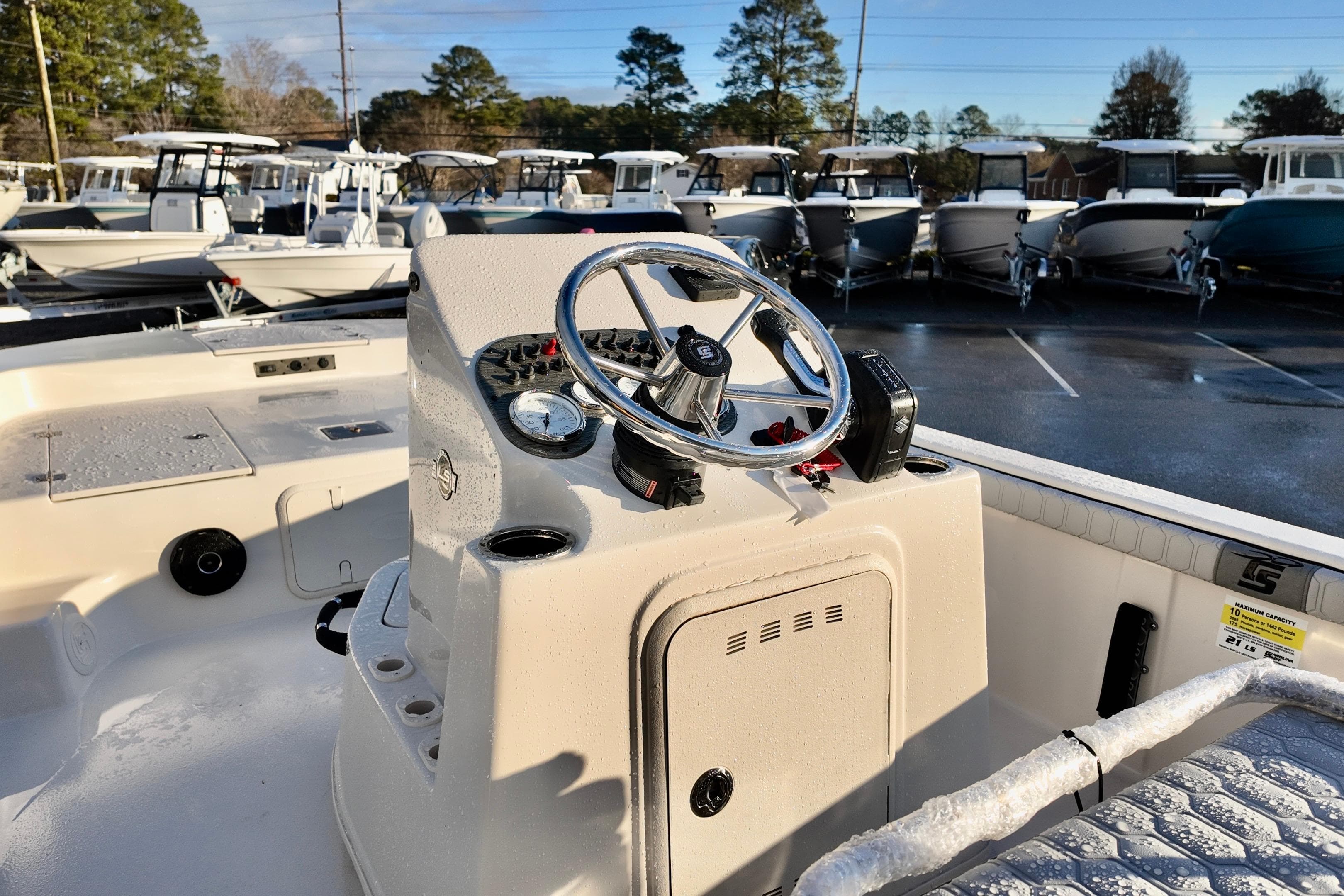 2026 Carolina Skiff 21 LS boat interior with steering wheel, parked in a marina.