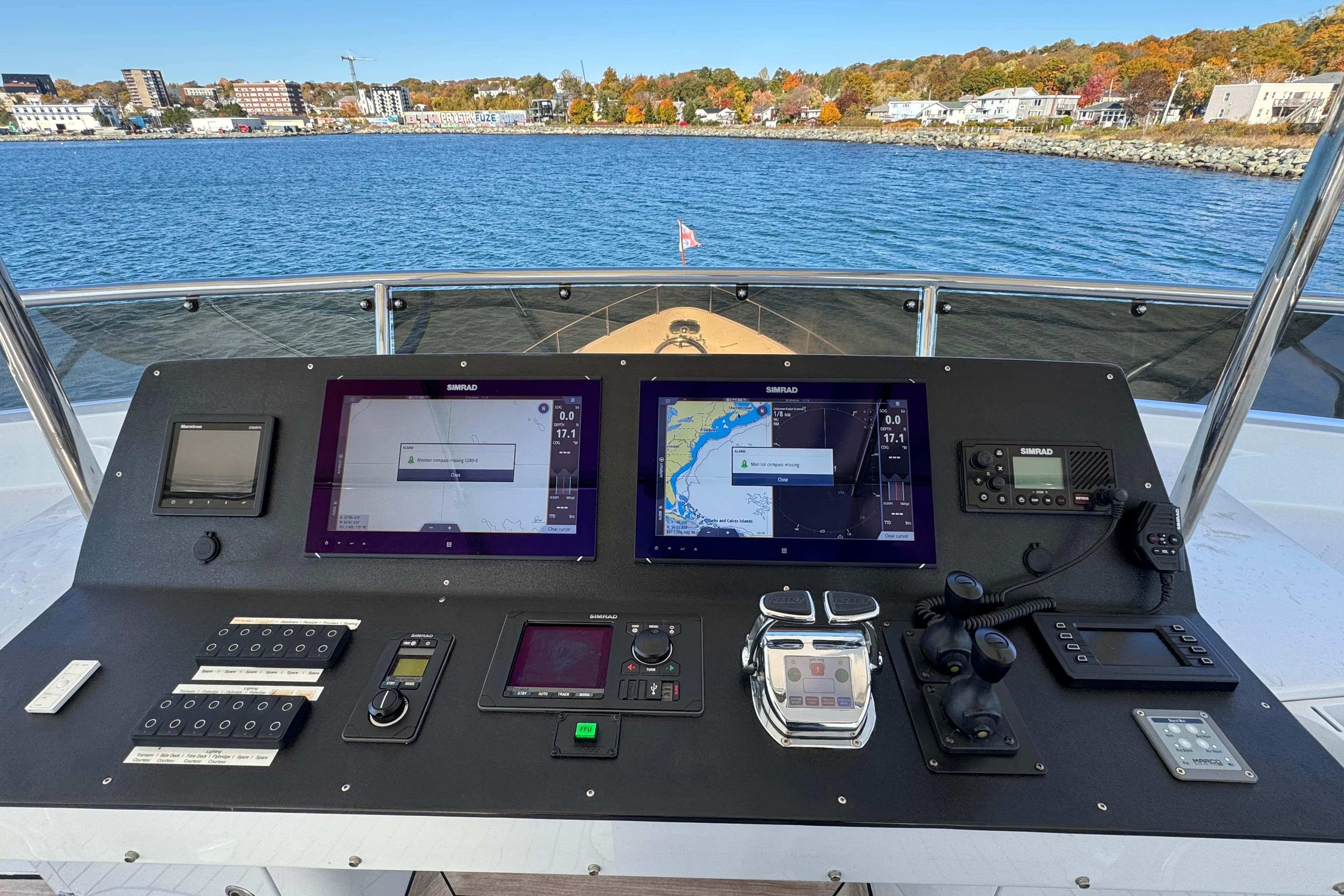 Boat control panel with navigation screens, Doogersbank Vipack 2001, overlooking scenic waterfront.