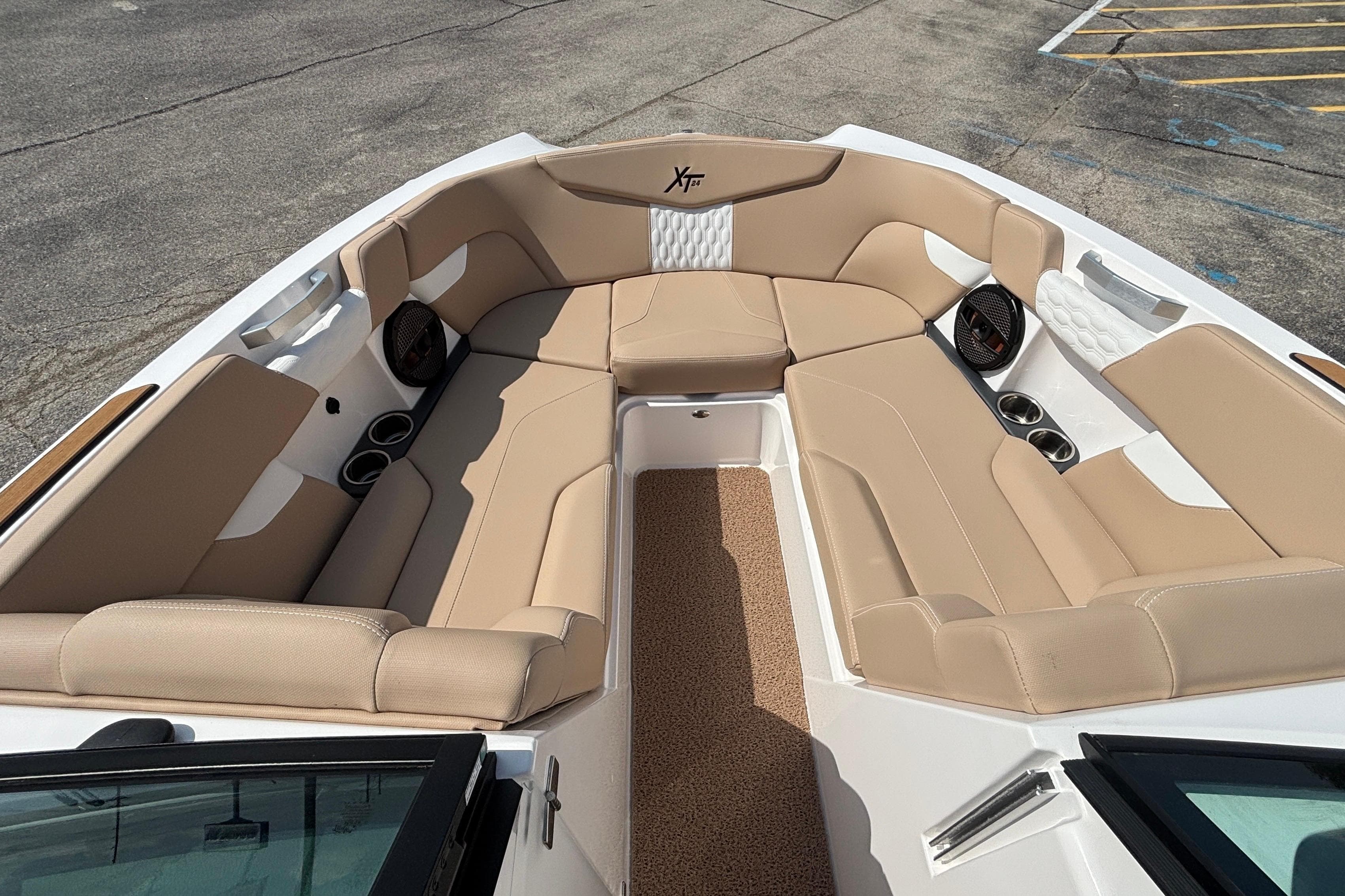 Luxurious interior of 2024 MasterCraft XT24 boat with beige seating and cup holders.