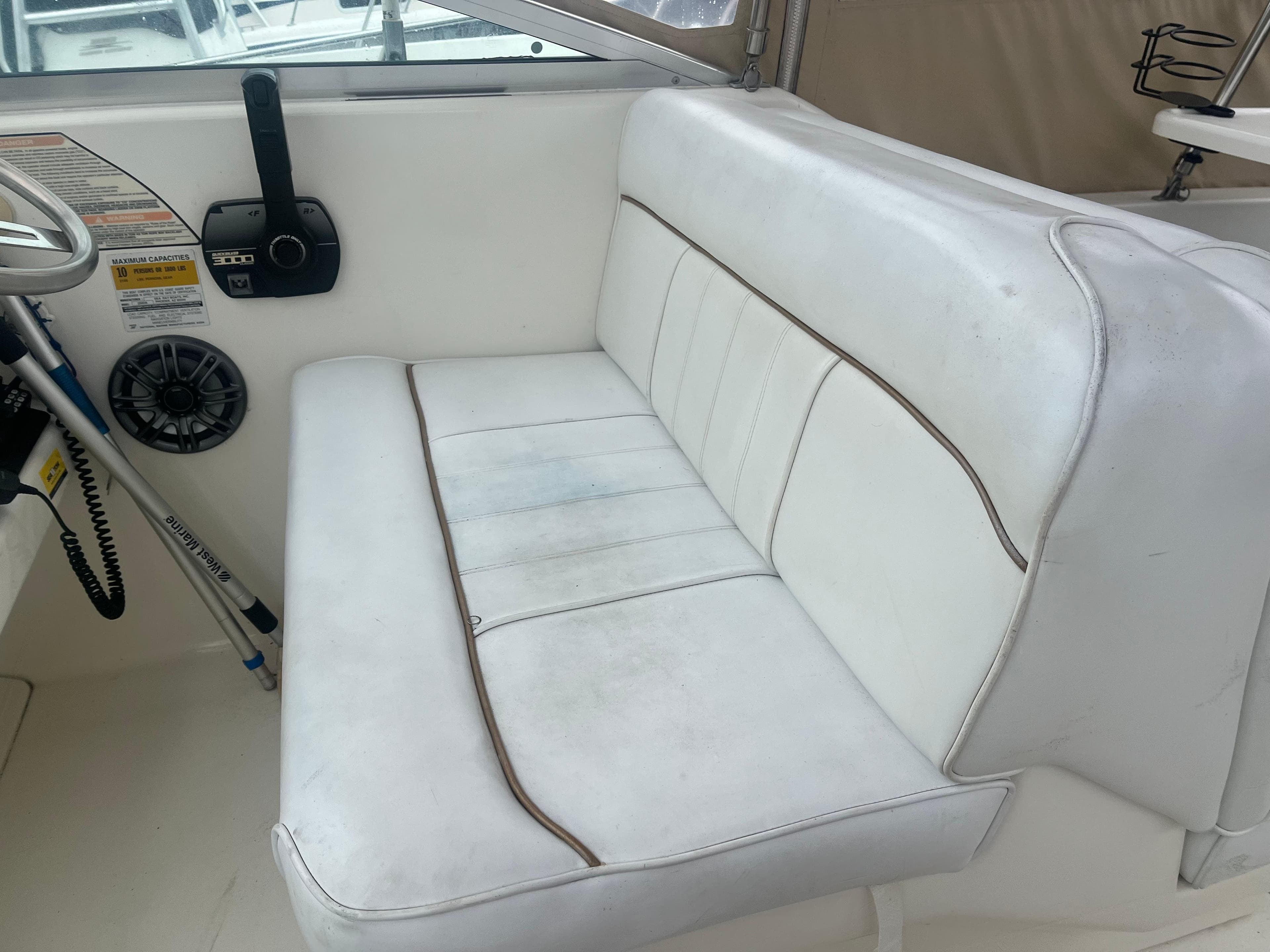 1995 Sea Ray 250 Sundancer interior seating with white upholstery and control panel.
