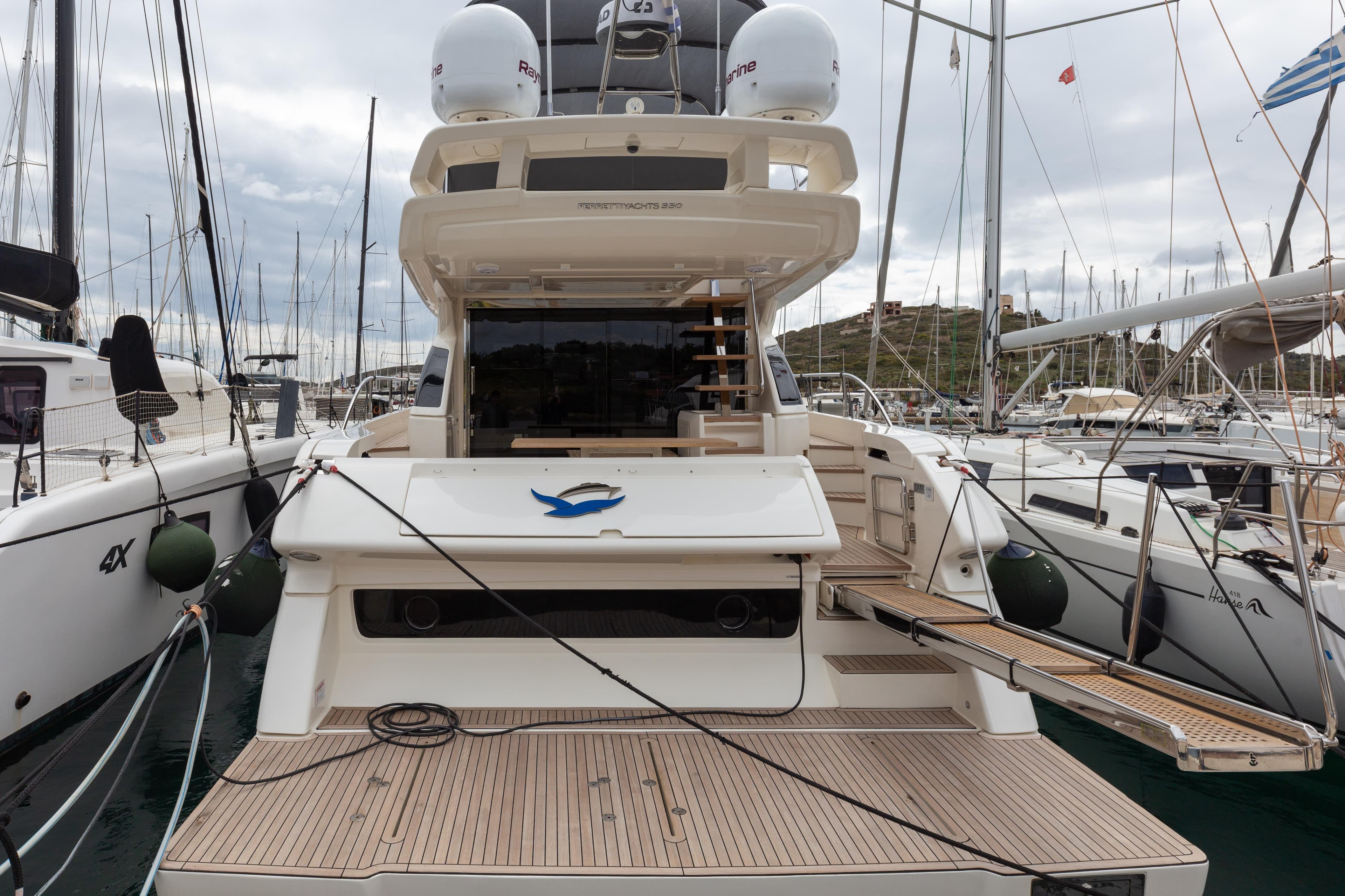 2022 Ferretti Yachts 550 docked at marina, showcasing elegant design and spacious deck.