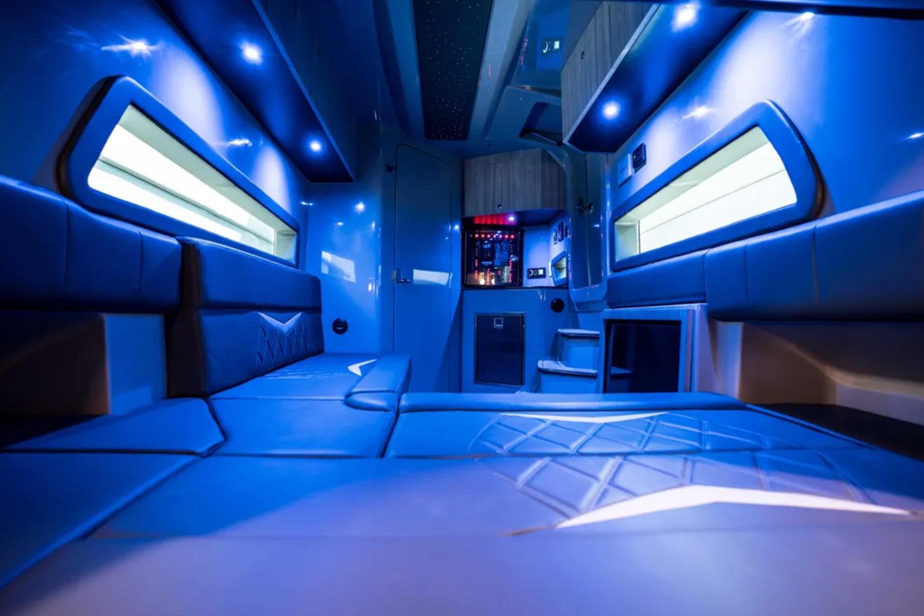 Luxurious interior of 2026 Deep Impact 499 Sport boat with blue ambient lighting.