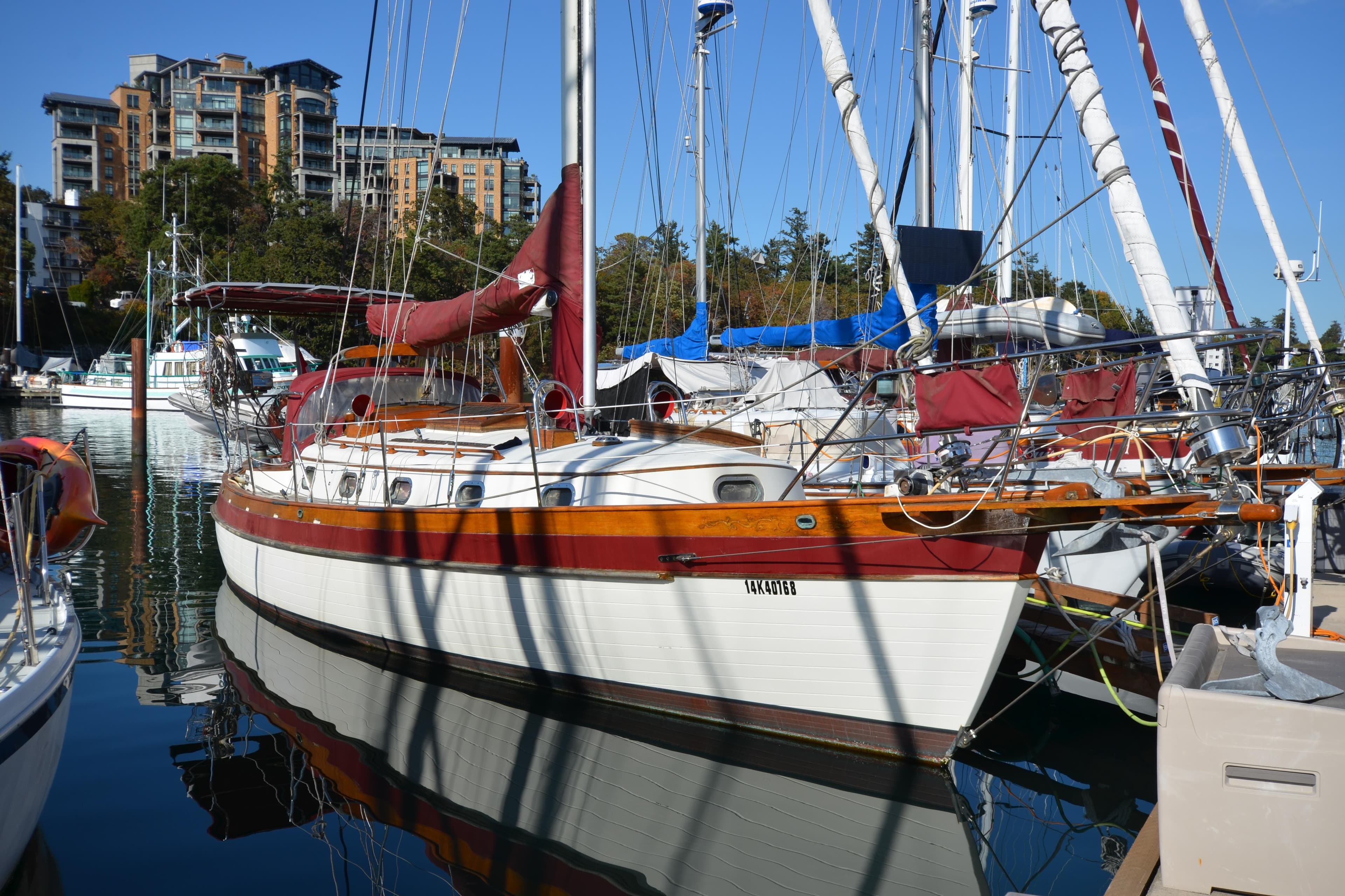 1982 Ta Shing Panada sailboat docked in marina, surrounded by other boats and buildings.