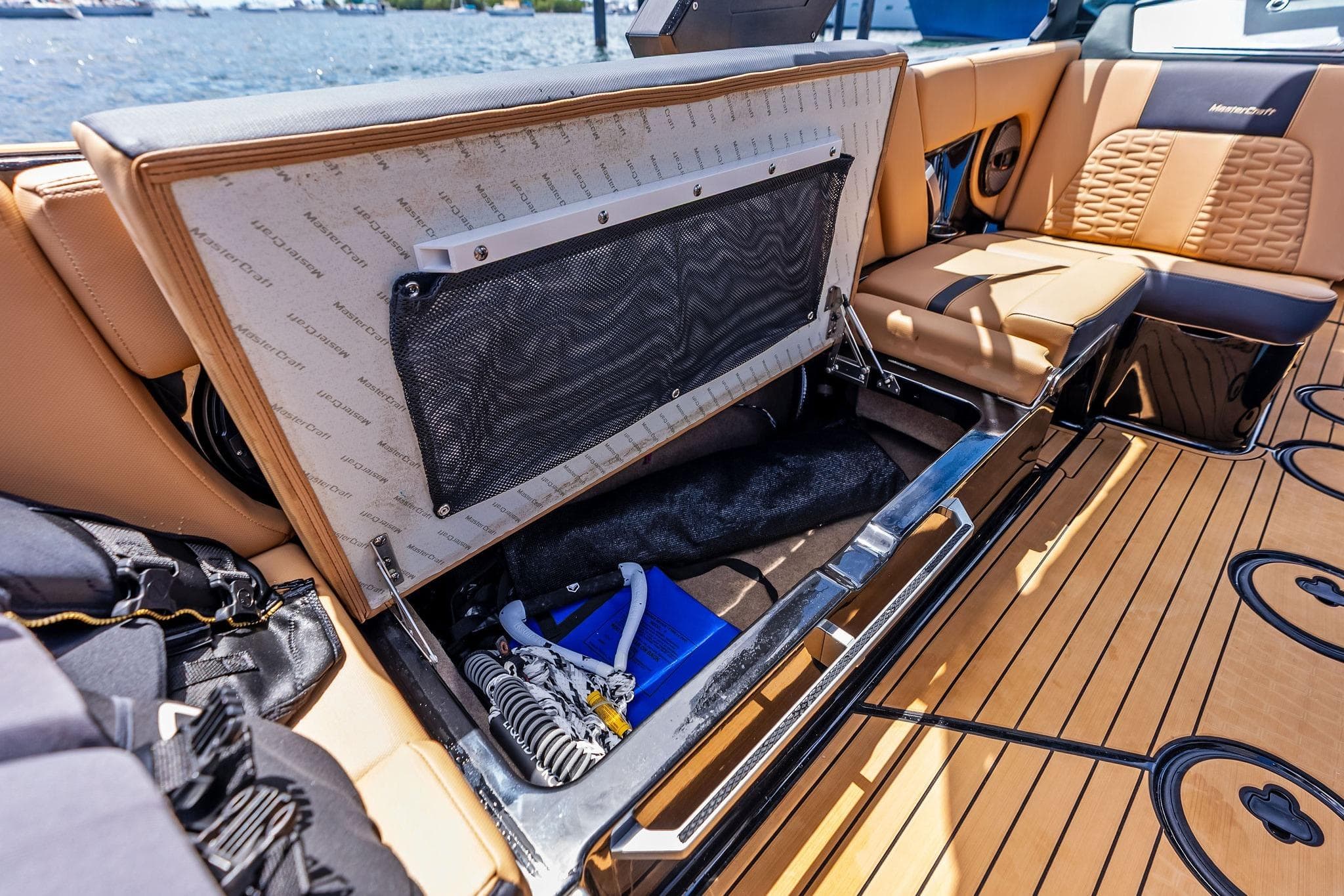 2024 MasterCraft X24 boat interior storage compartment with luxury seating and teak flooring.