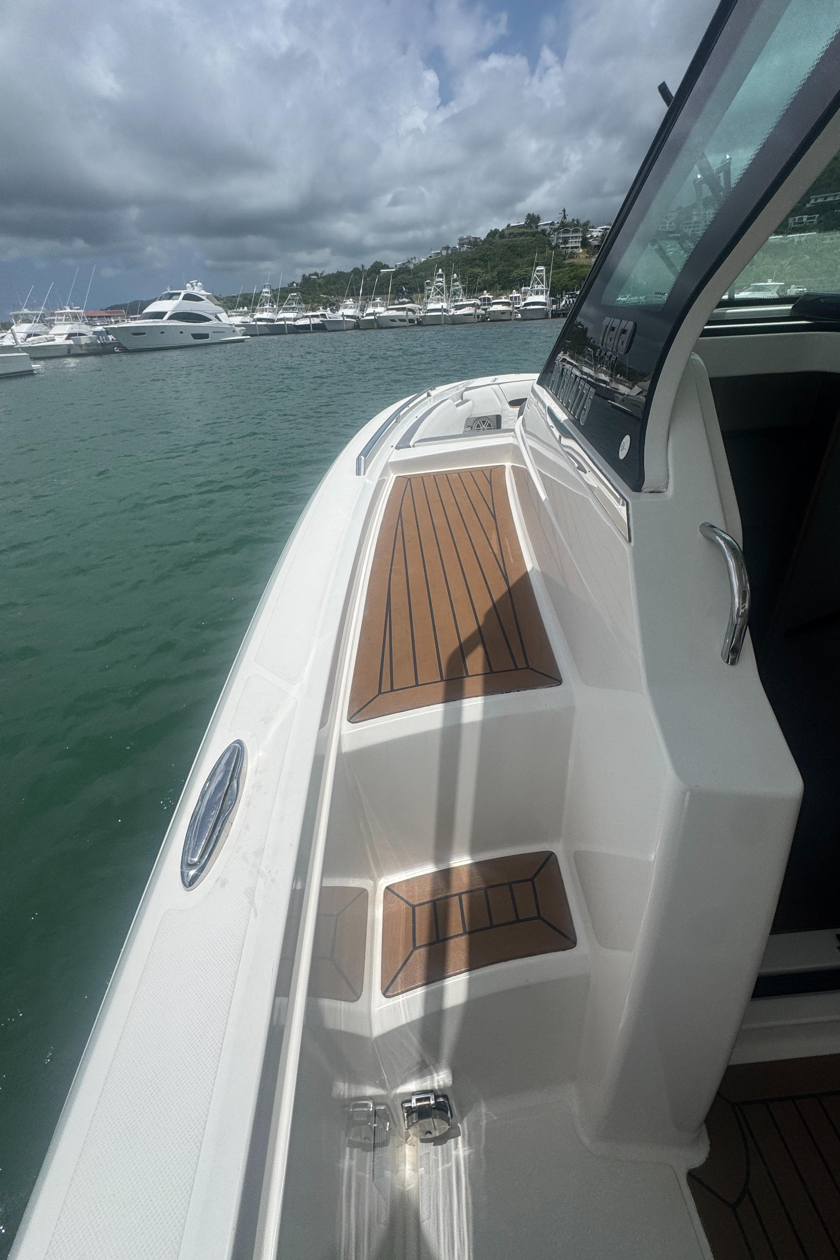 2020 Tiara Sport 34 LS boat docked in marina, featuring sleek design and wooden deck.