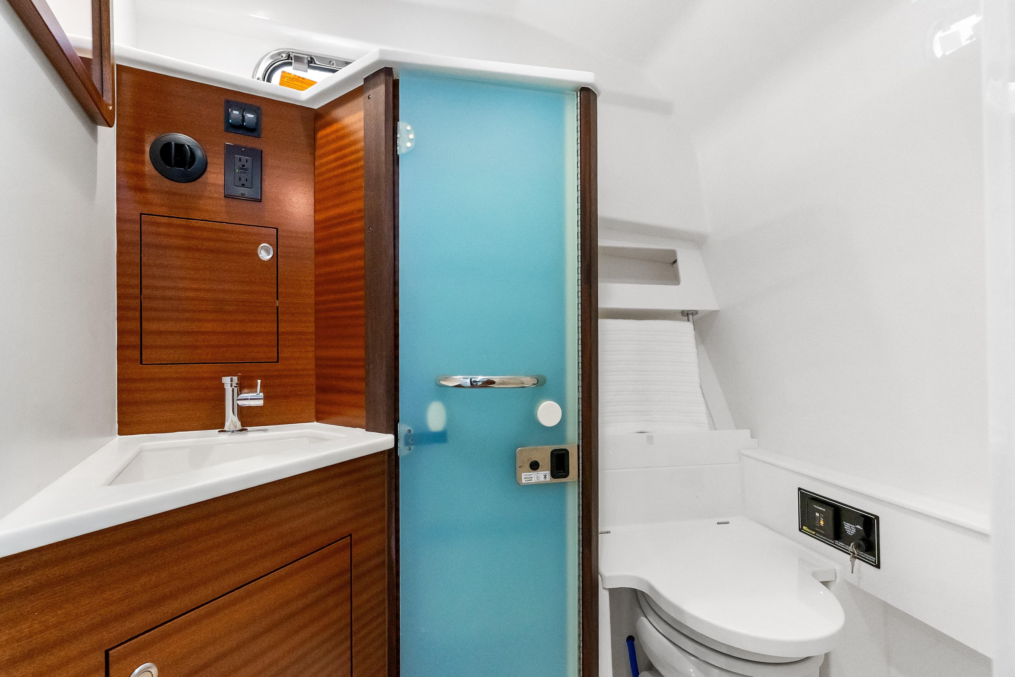 Luxurious bathroom in 2026 Pursuit OS 405 Offshore boat with modern fixtures and wood accents.