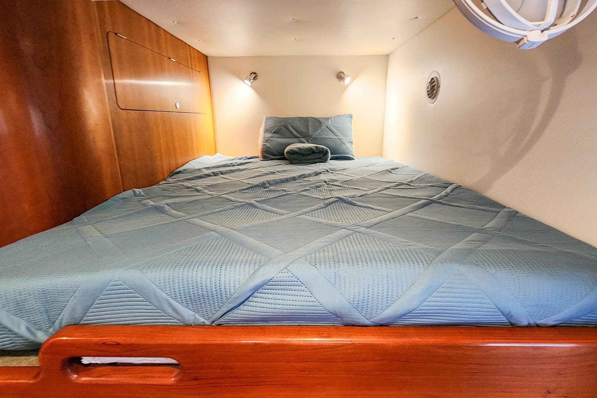 Cozy cabin bed in 2019 Antares 44GT yacht with wooden accents and soft lighting.
