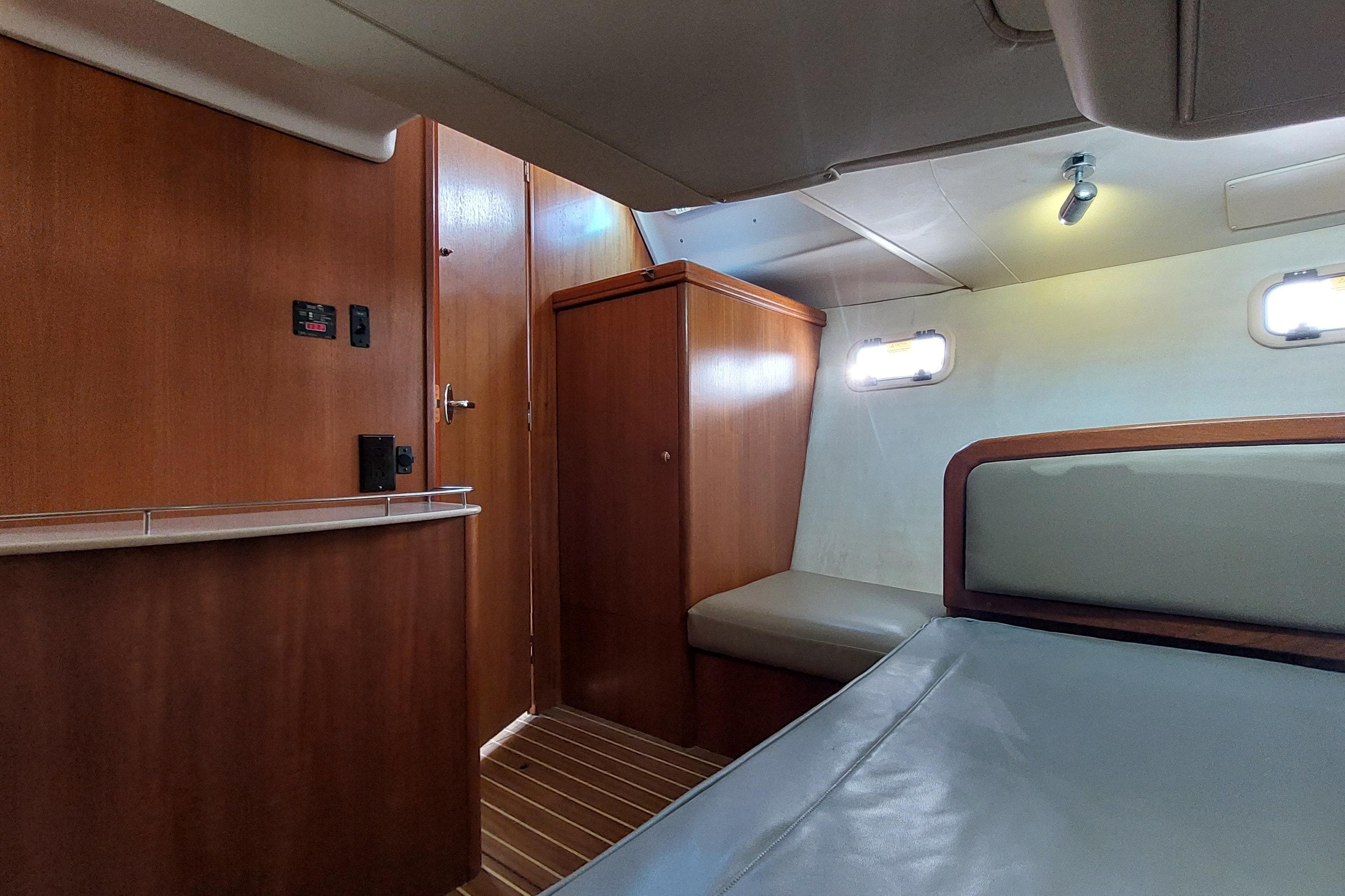 Interior cabin of a 2005 Hunter 38 sailboat with wooden furnishings and cozy seating.