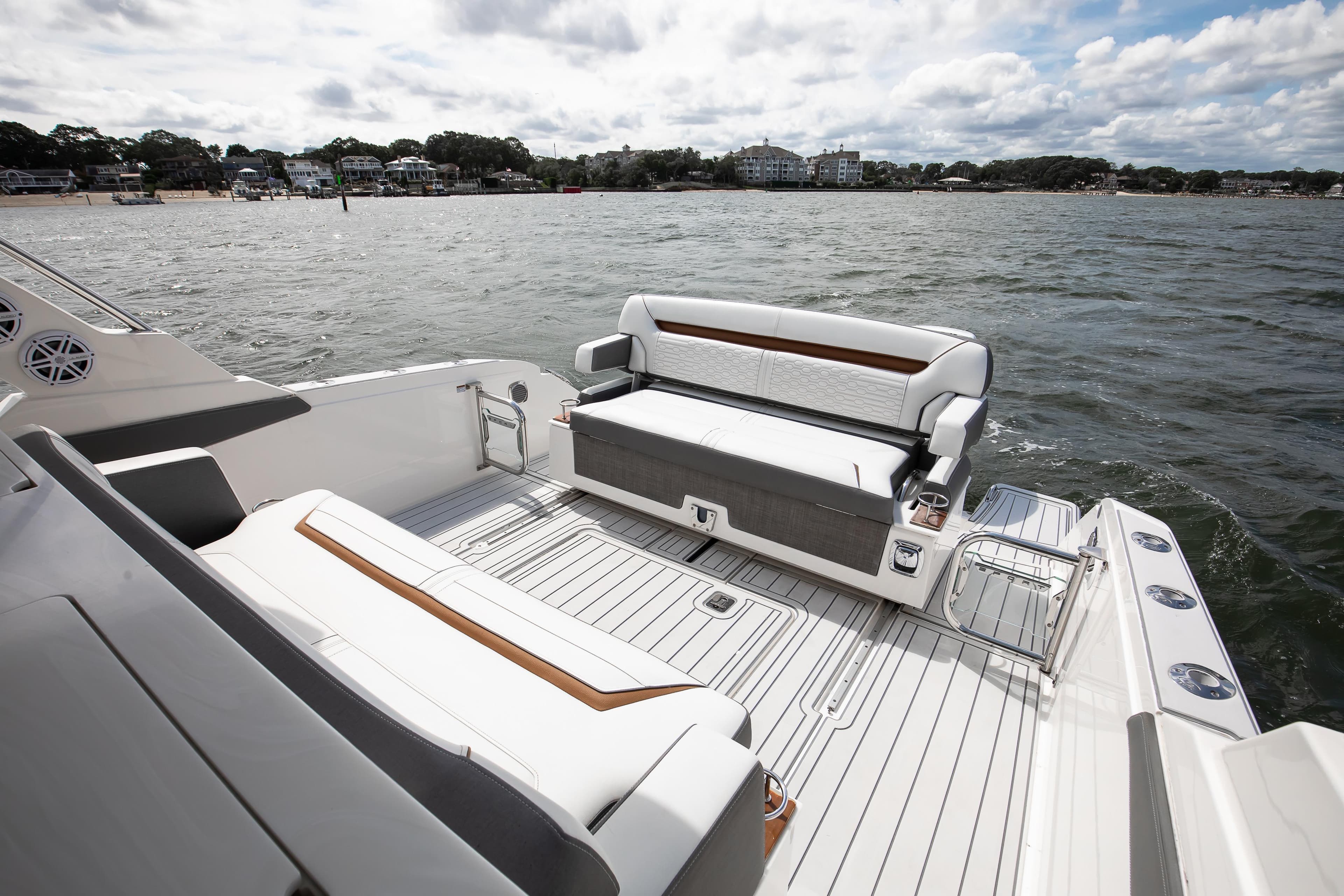 2020 Tiara Sport 34 LS boat interior with seating, on a scenic waterfront.