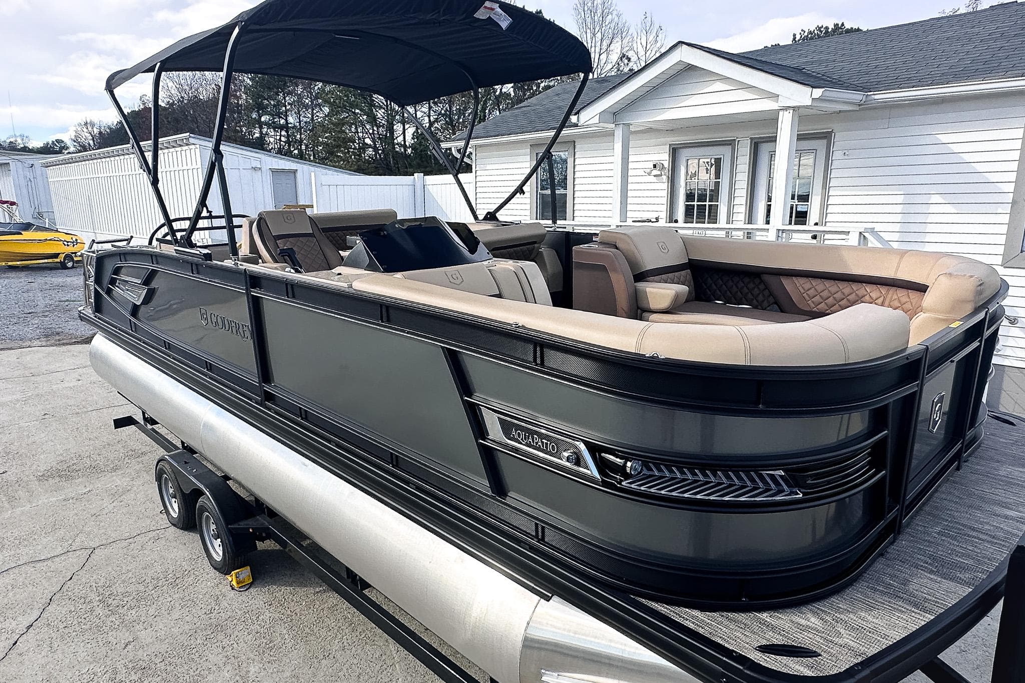 2025 Godfrey AquaPatio 25' Flip Lounge Tritoon on trailer, featuring sleek design and spacious seating.