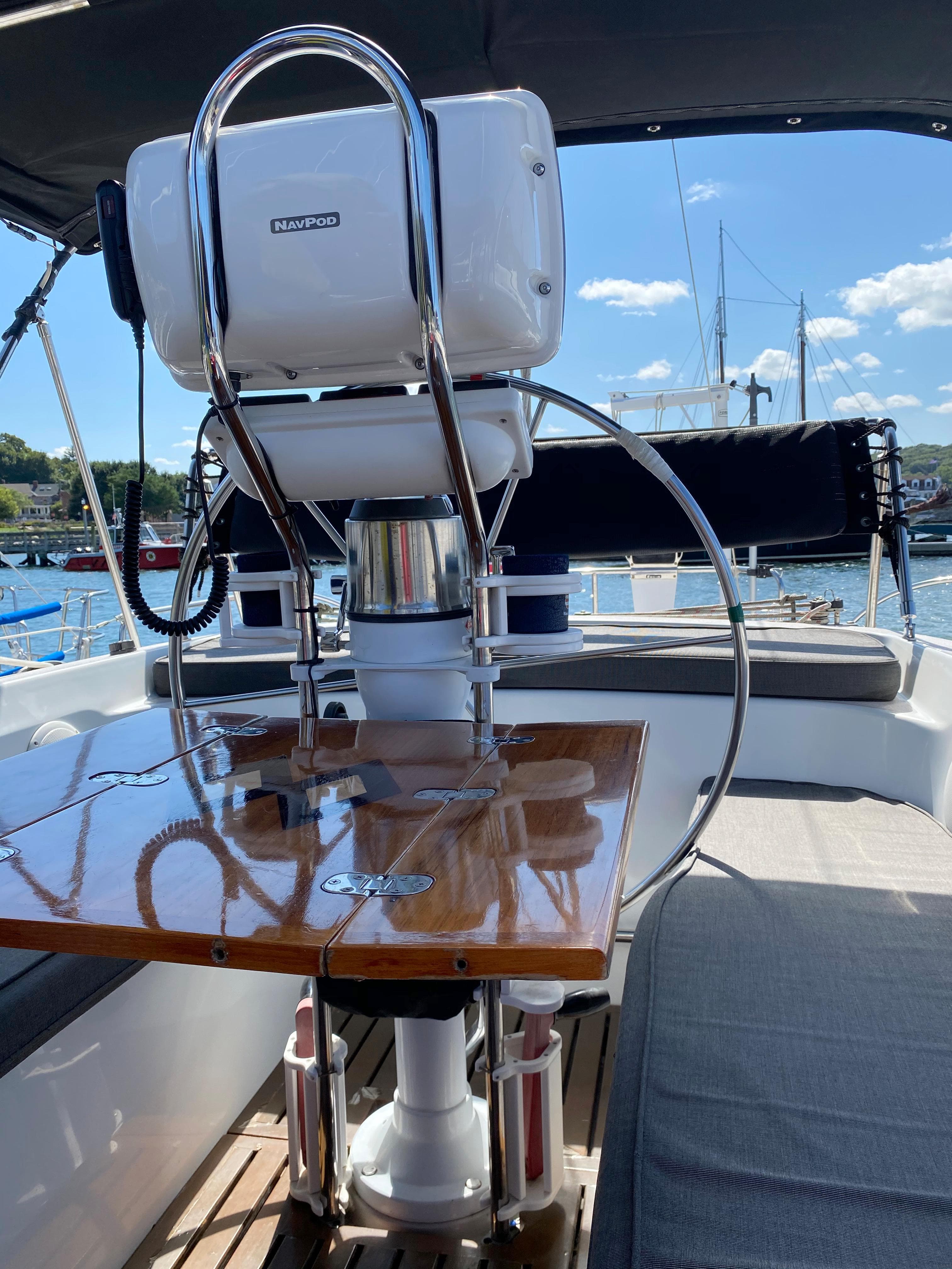 Cockpit of 1997 Catalina Morgan 38 sailboat with polished wooden table and steering wheel.