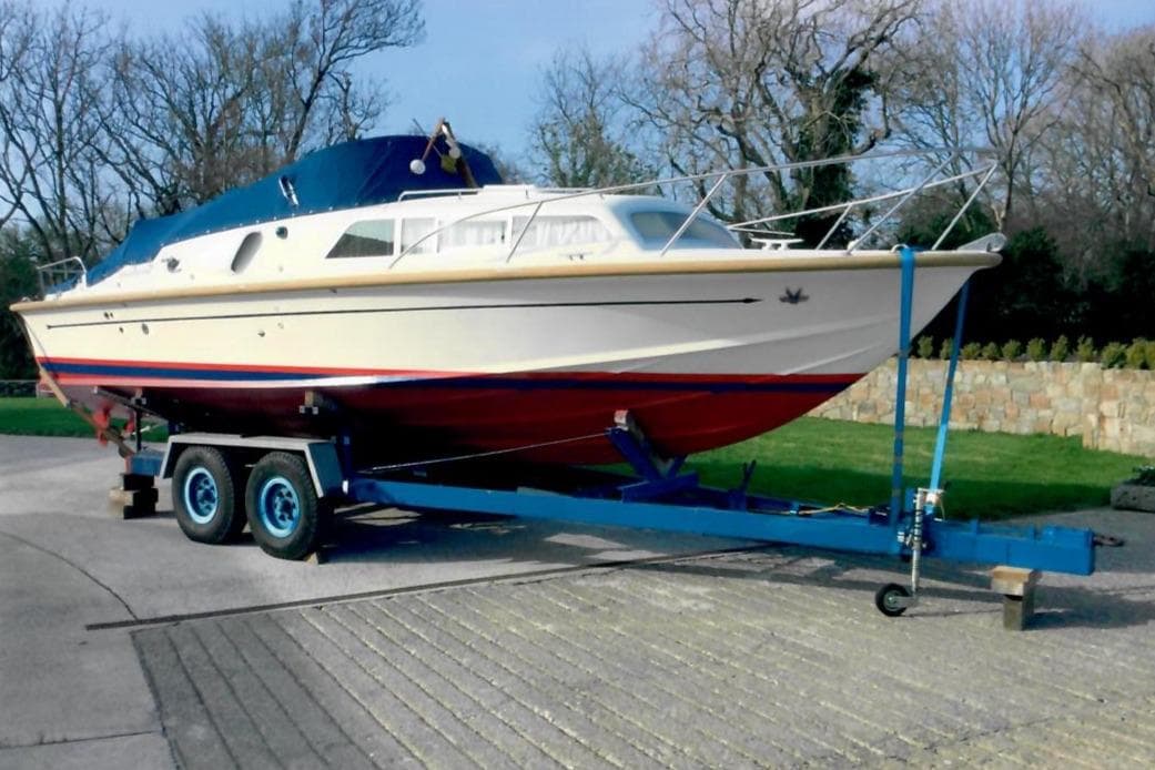 1989 Fairey Spearfish MKIII boat on trailer, parked outdoors, surrounded by trees.