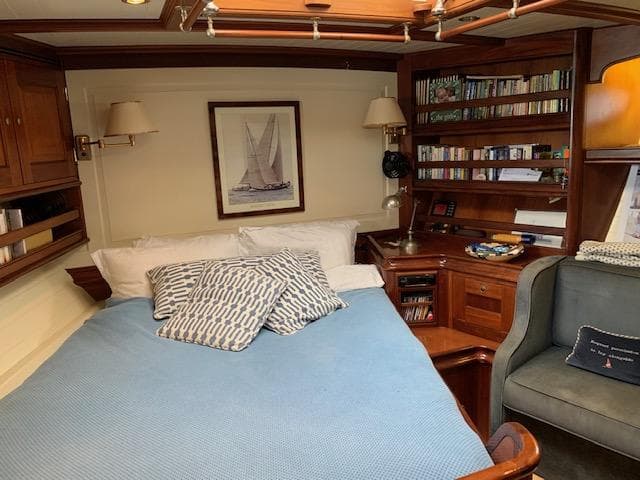 Luxurious cabin interior of 1997 Hoek Truly Classic yacht with cozy bed and wooden furnishings.