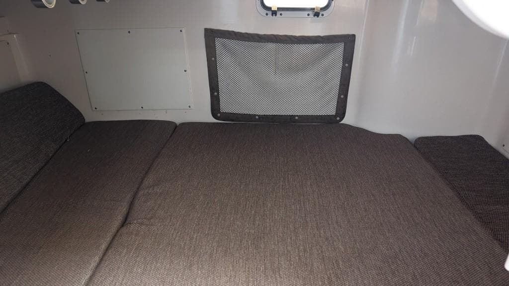 Interior cabin of 2006 Grady-White Marlin 300 boat with cushioned bed.
