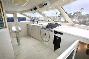 Luxurious 1989 custom yacht interior with modern helm, panoramic windows, and sleek design.