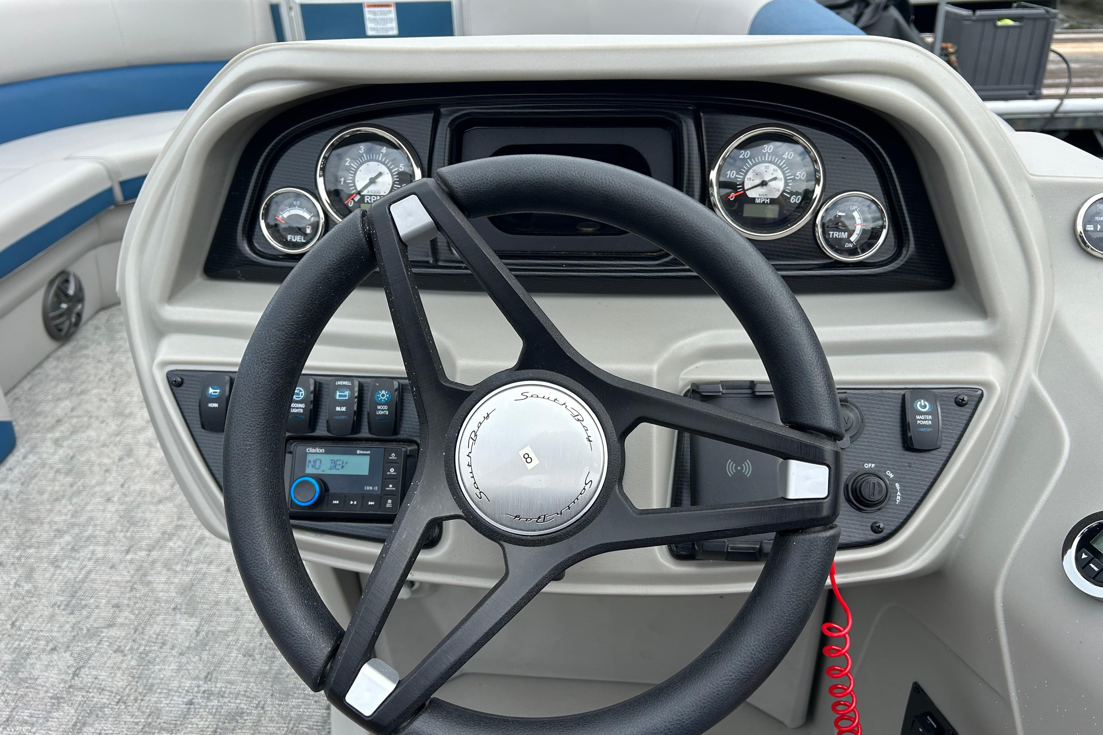 Steering console of 2025 Southbay 224RSLE25 boat with gauges and controls.