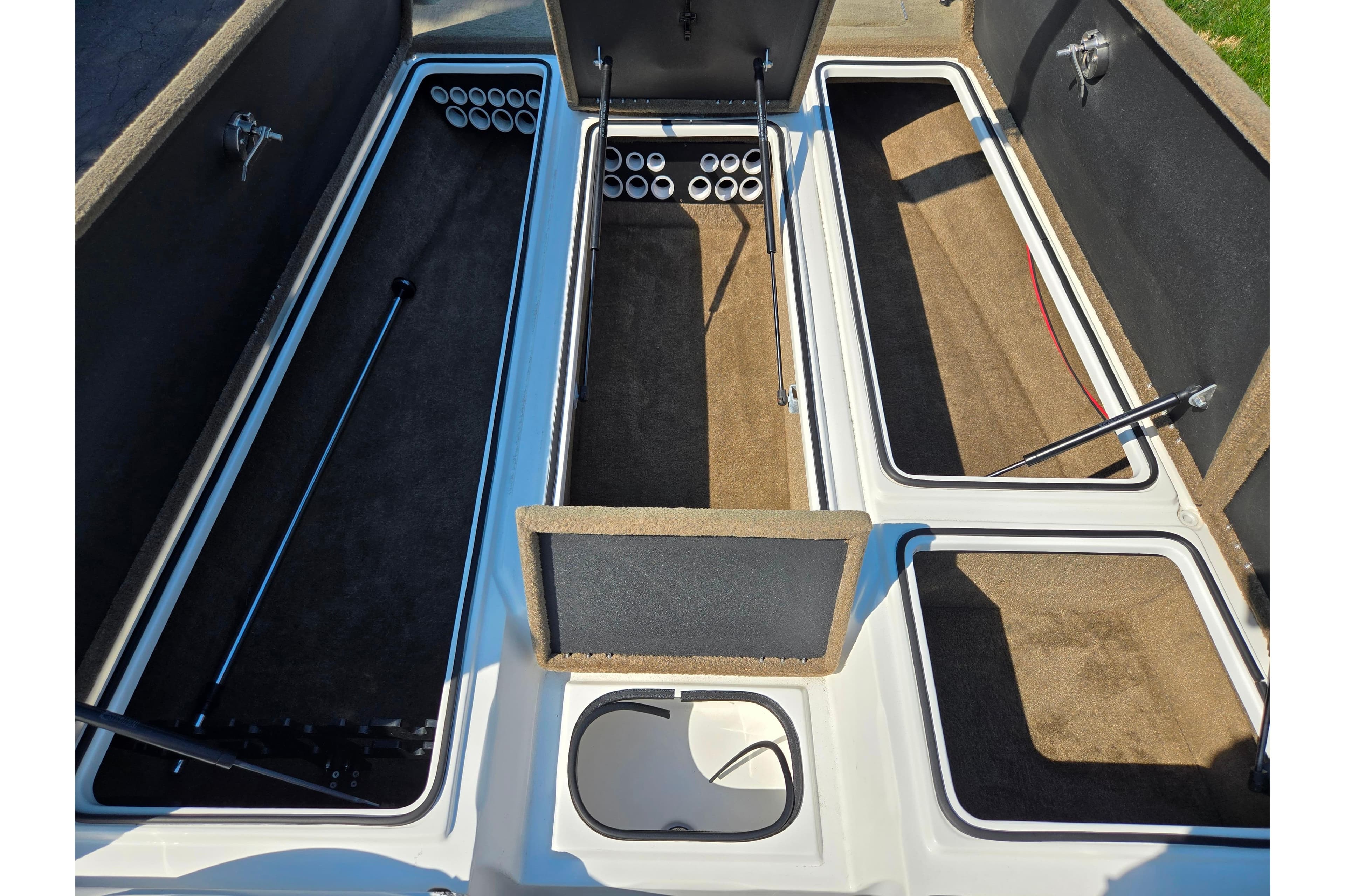 2016 Legend Alpha 211R DC boat storage compartments with rod holders and carpeted interiors.