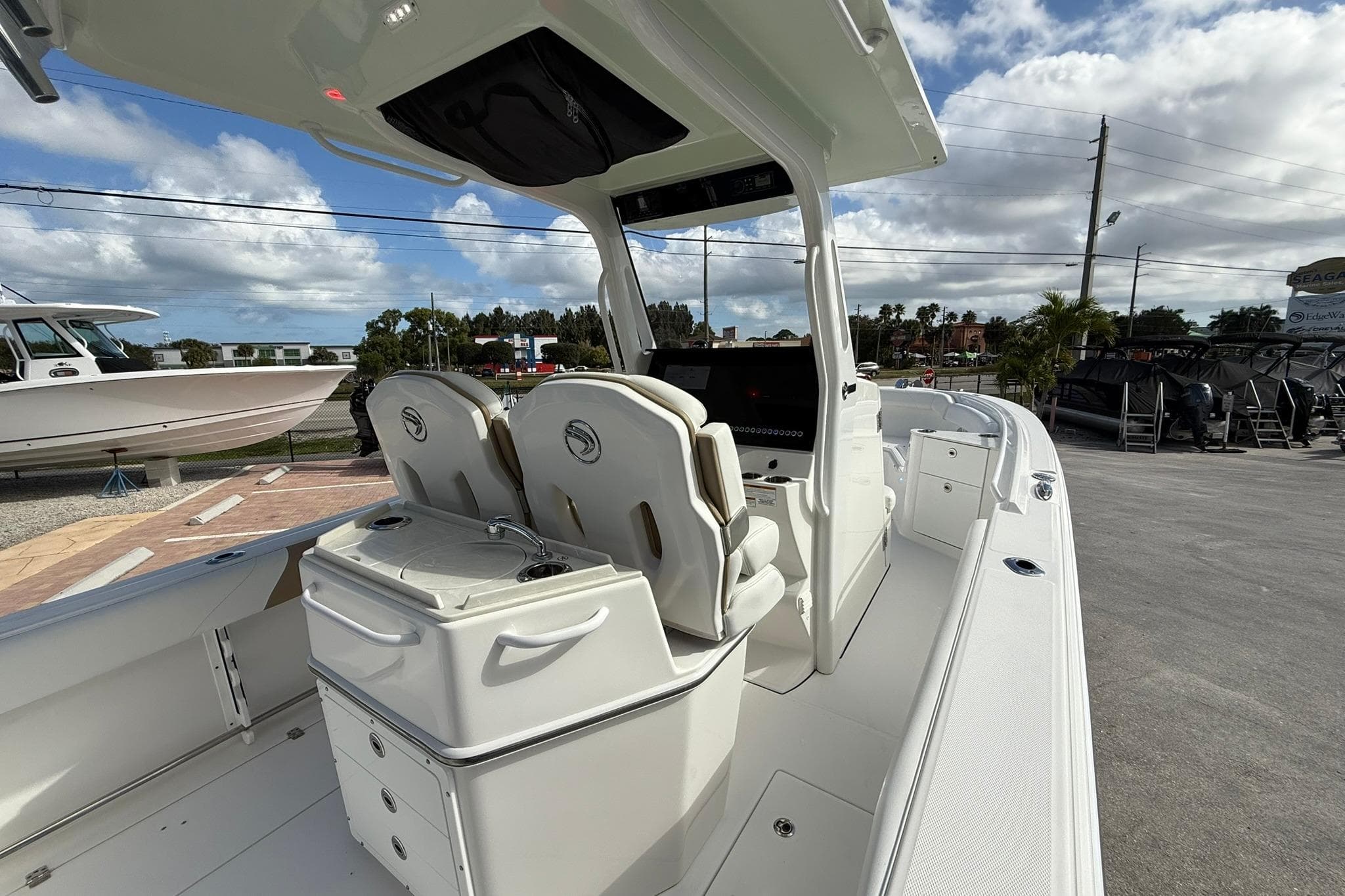 2021 Edgewater 262CC boat interior with dual seats and console, under a partly cloudy sky.