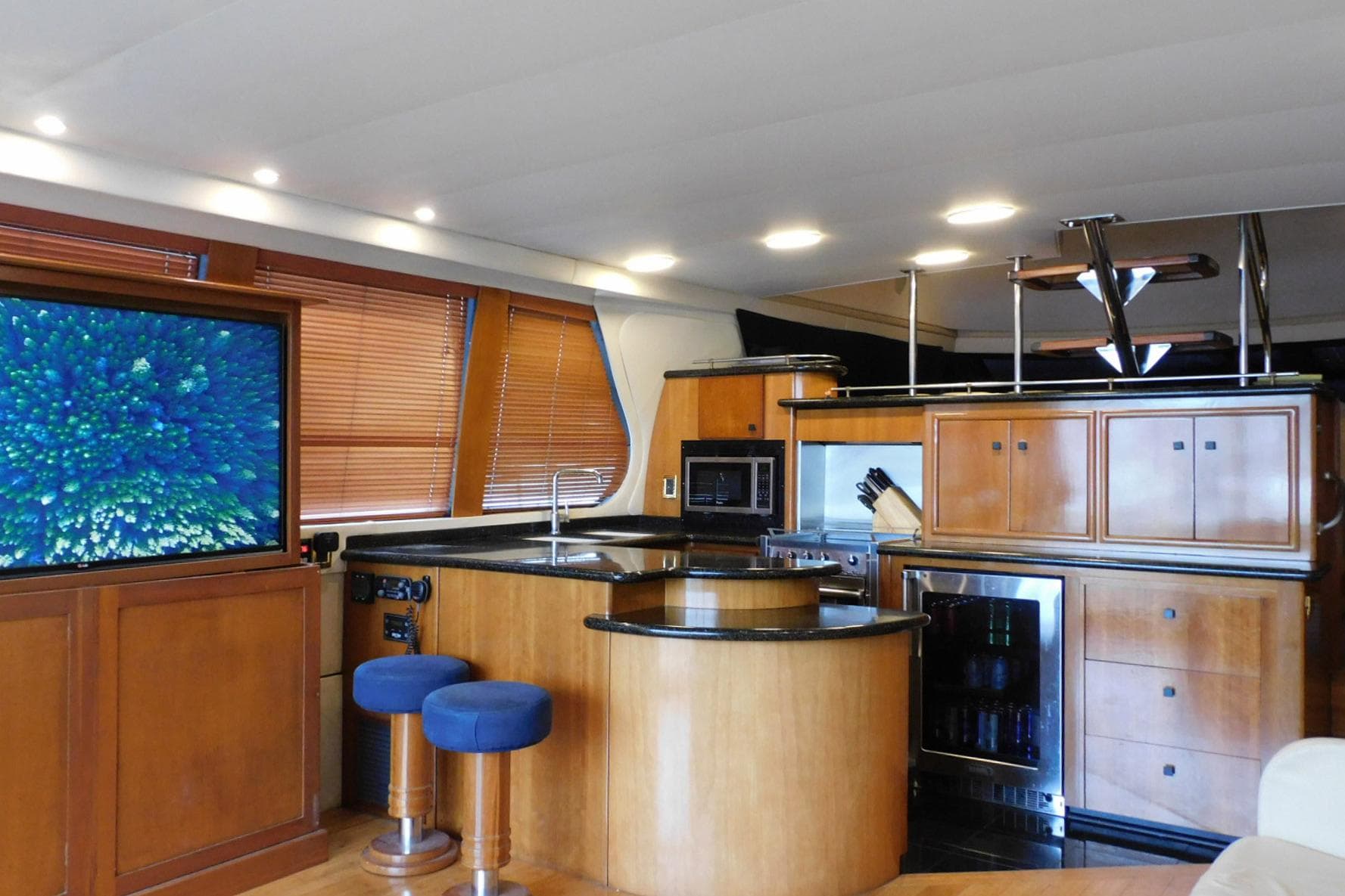 Luxurious interior of 2002 Carver 570 Voyager Pilothouse yacht with modern kitchen and entertainment area.
