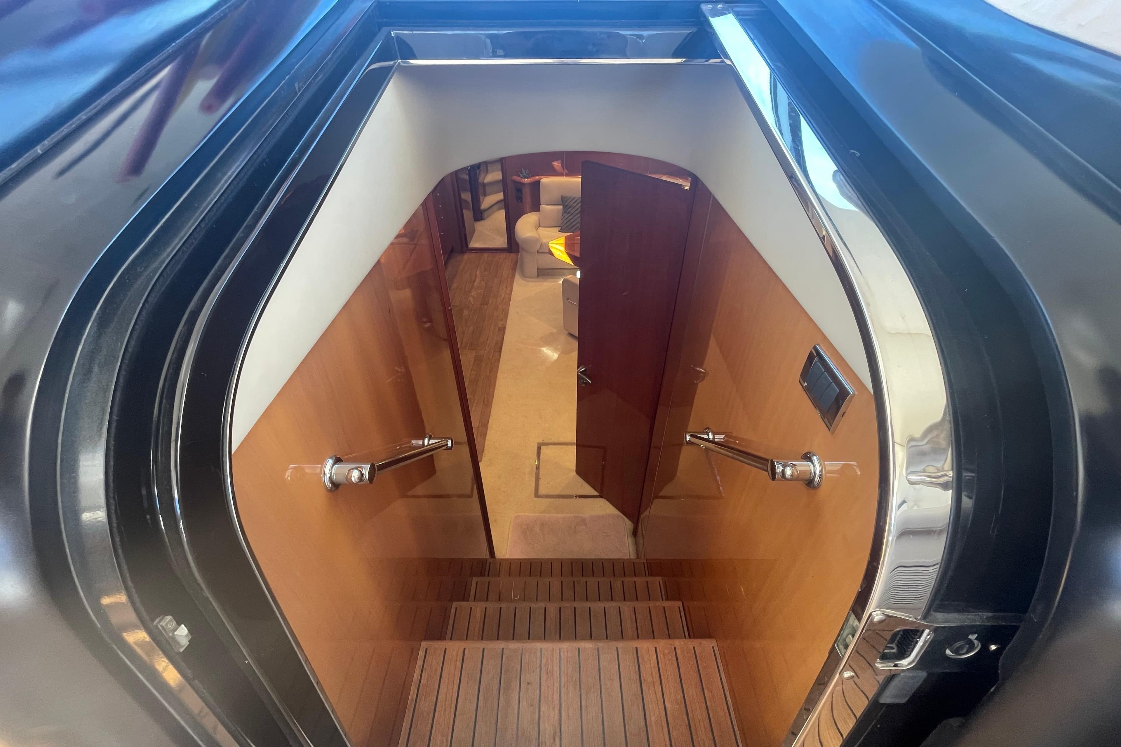Interior staircase of 2003 Sunseeker Predator 68 yacht, featuring wooden steps and modern design.