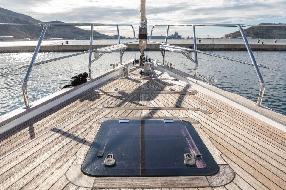 Deck view of 2015 Discovery 58 yacht, featuring sleek wooden finish and ocean backdrop.