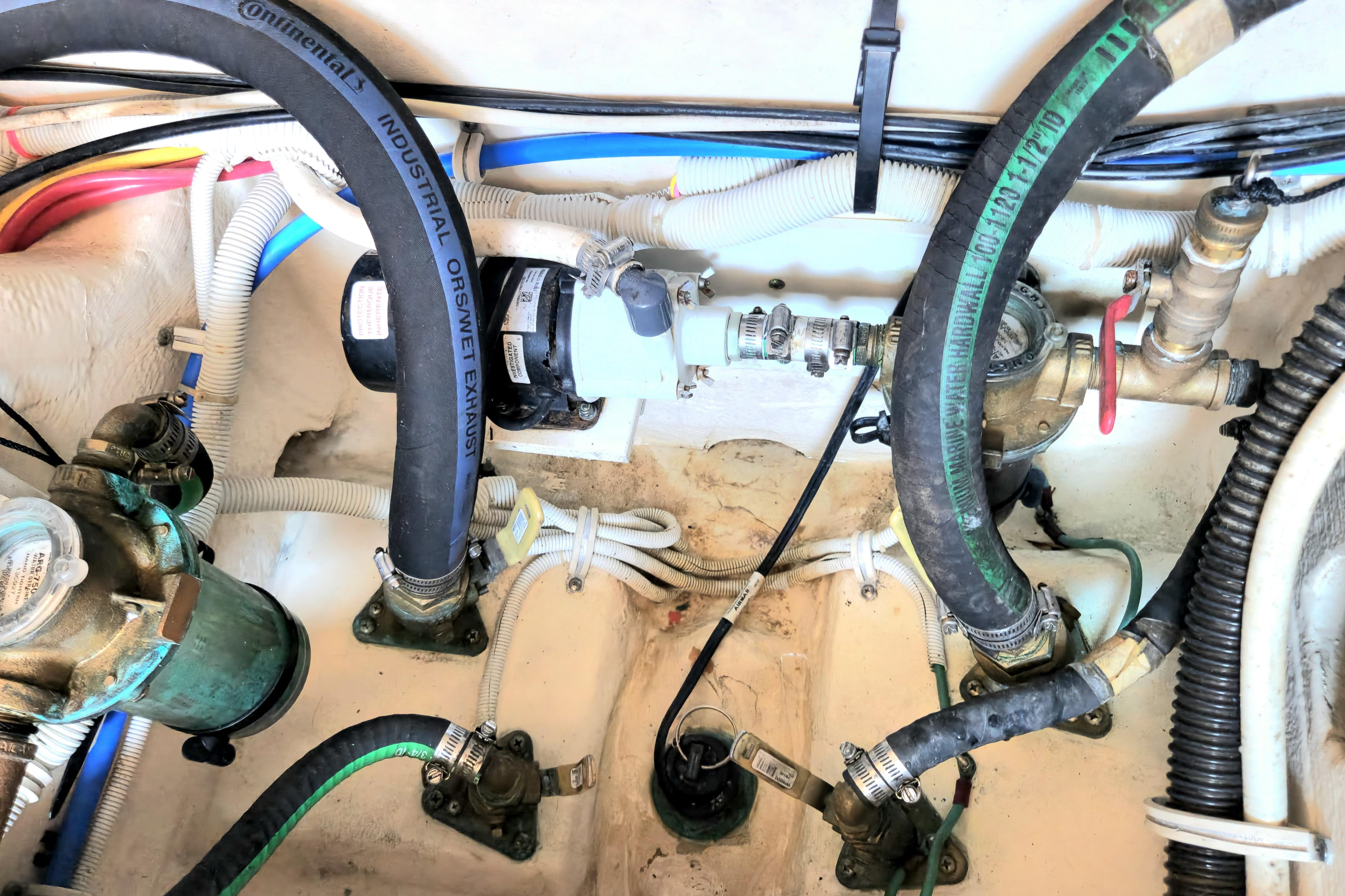 Engine compartment of a 2014 Tiara Yachts 3100 Coronet, showcasing hoses and mechanical components.