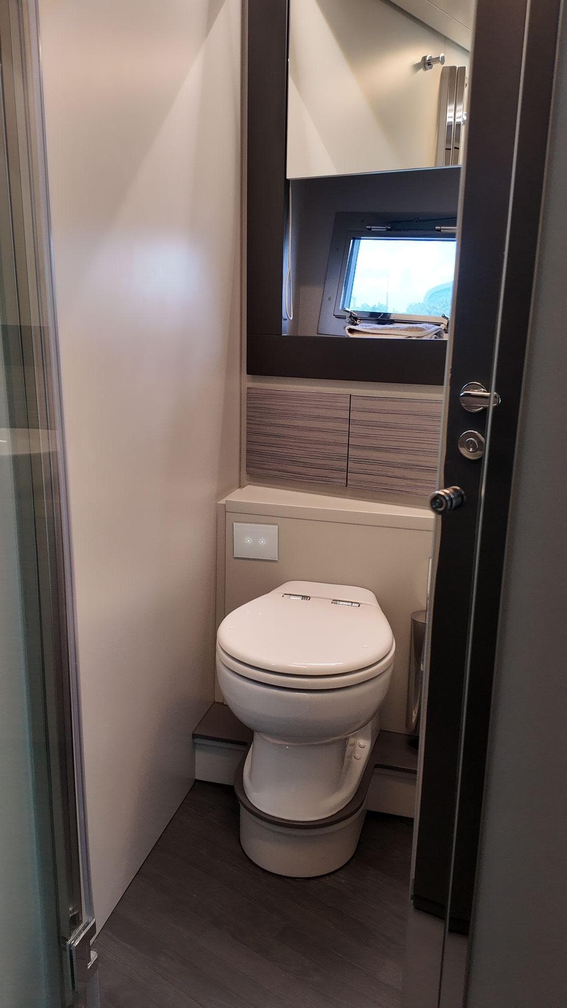 Modern bathroom interior in 2022 Pershing 6X yacht, featuring sleek design and compact layout.