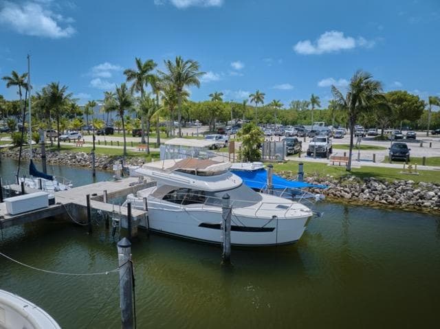 2015 Carver C34 Command Bridge yacht docked at a marina with palm trees.