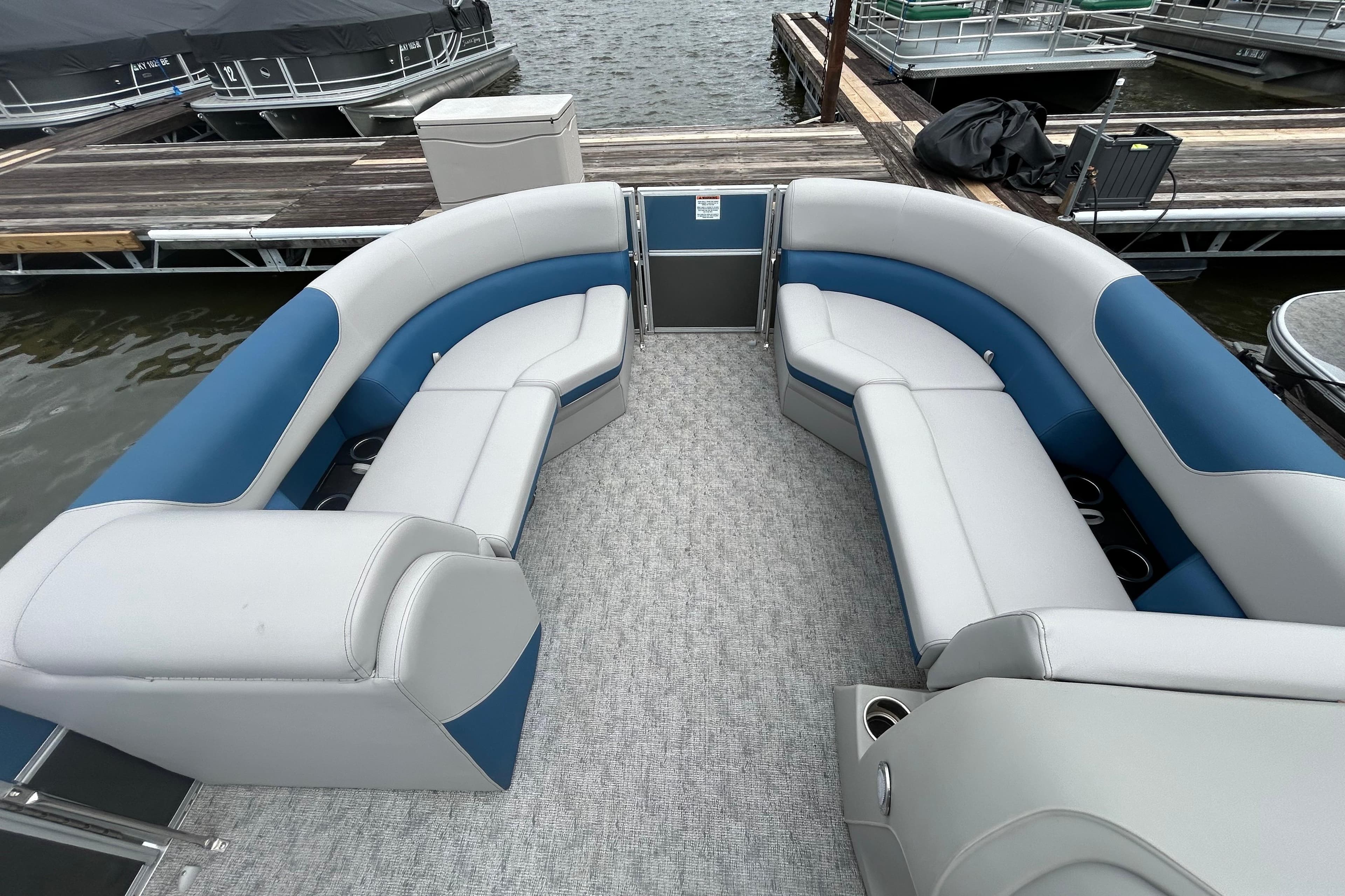 Luxurious 2025 Southbay 224RSLE25 pontoon boat with spacious seating at a dock.