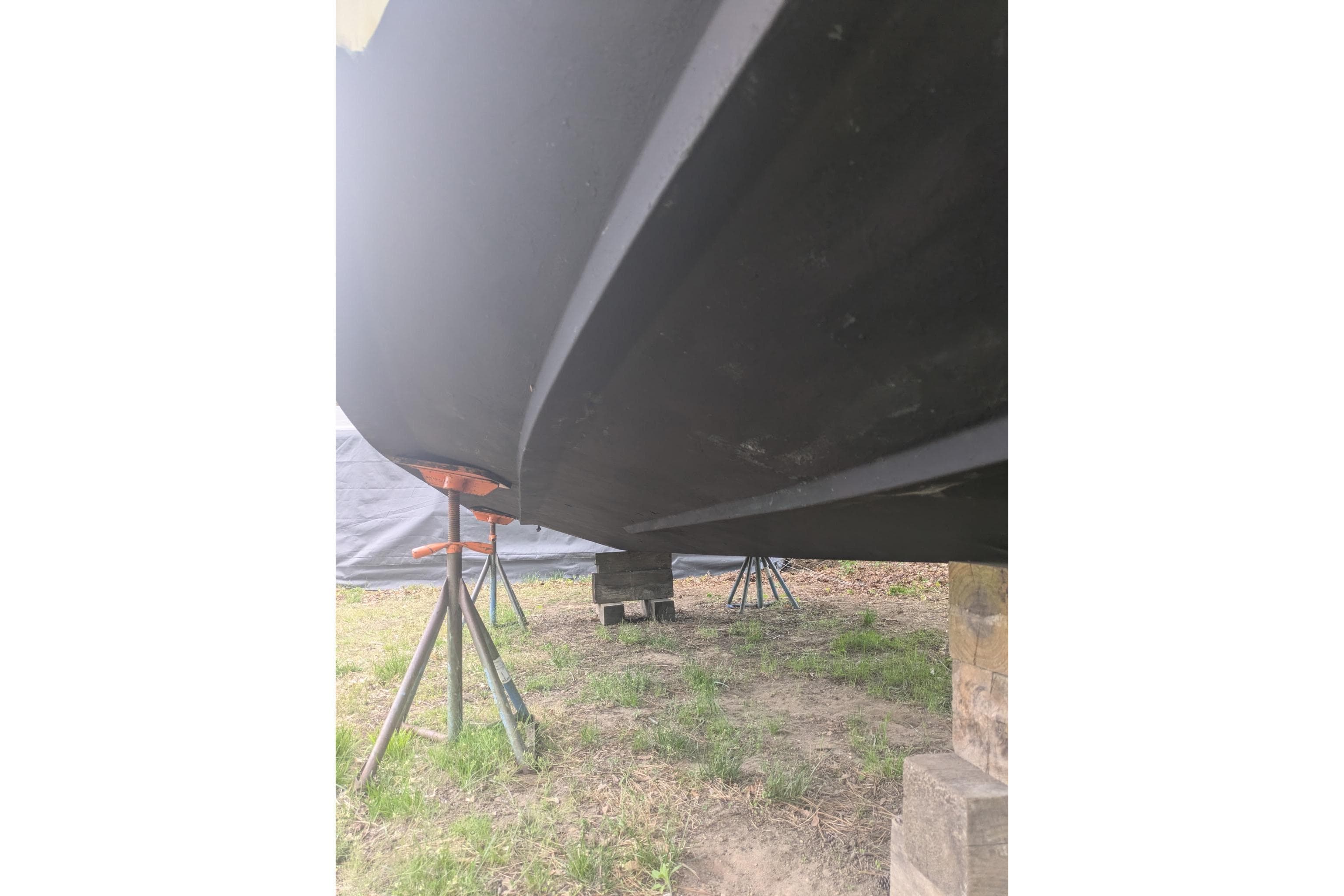 2016 Wellcraft 252 Coastal boat hull on stands, viewed from below.