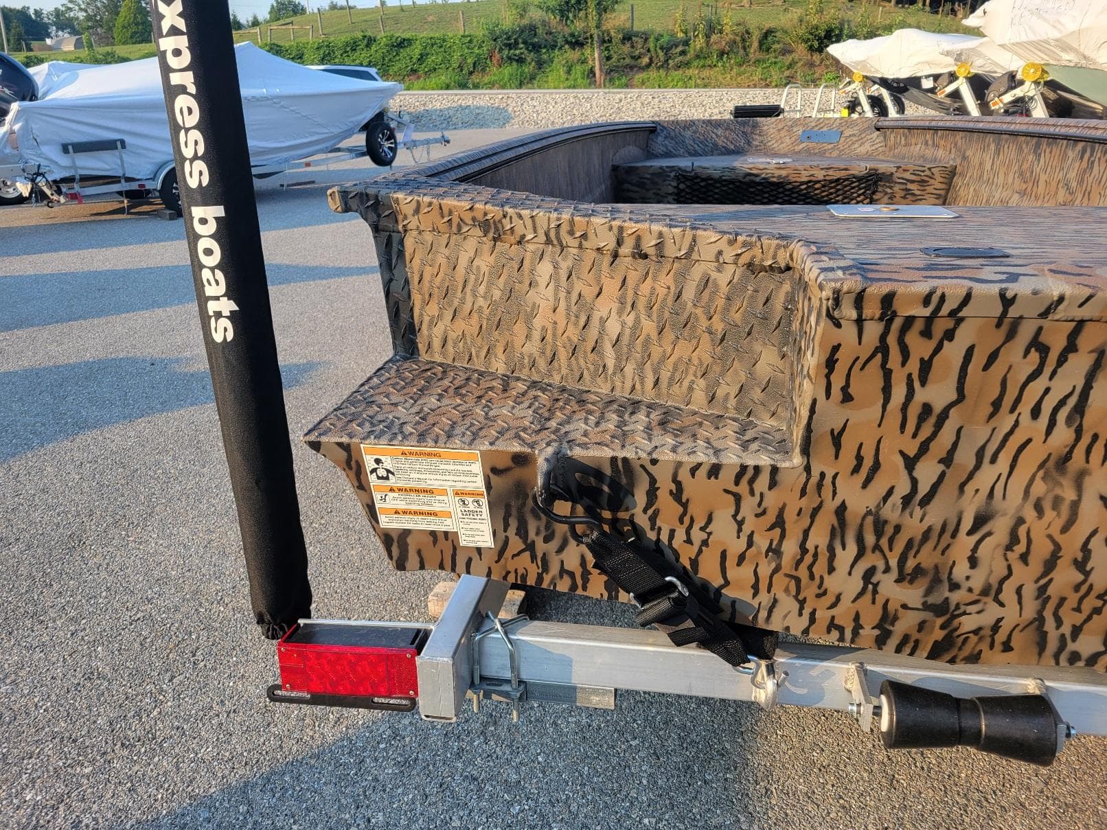 2026 Xpress XTS16 duck hunting boat with camouflage design on a trailer.