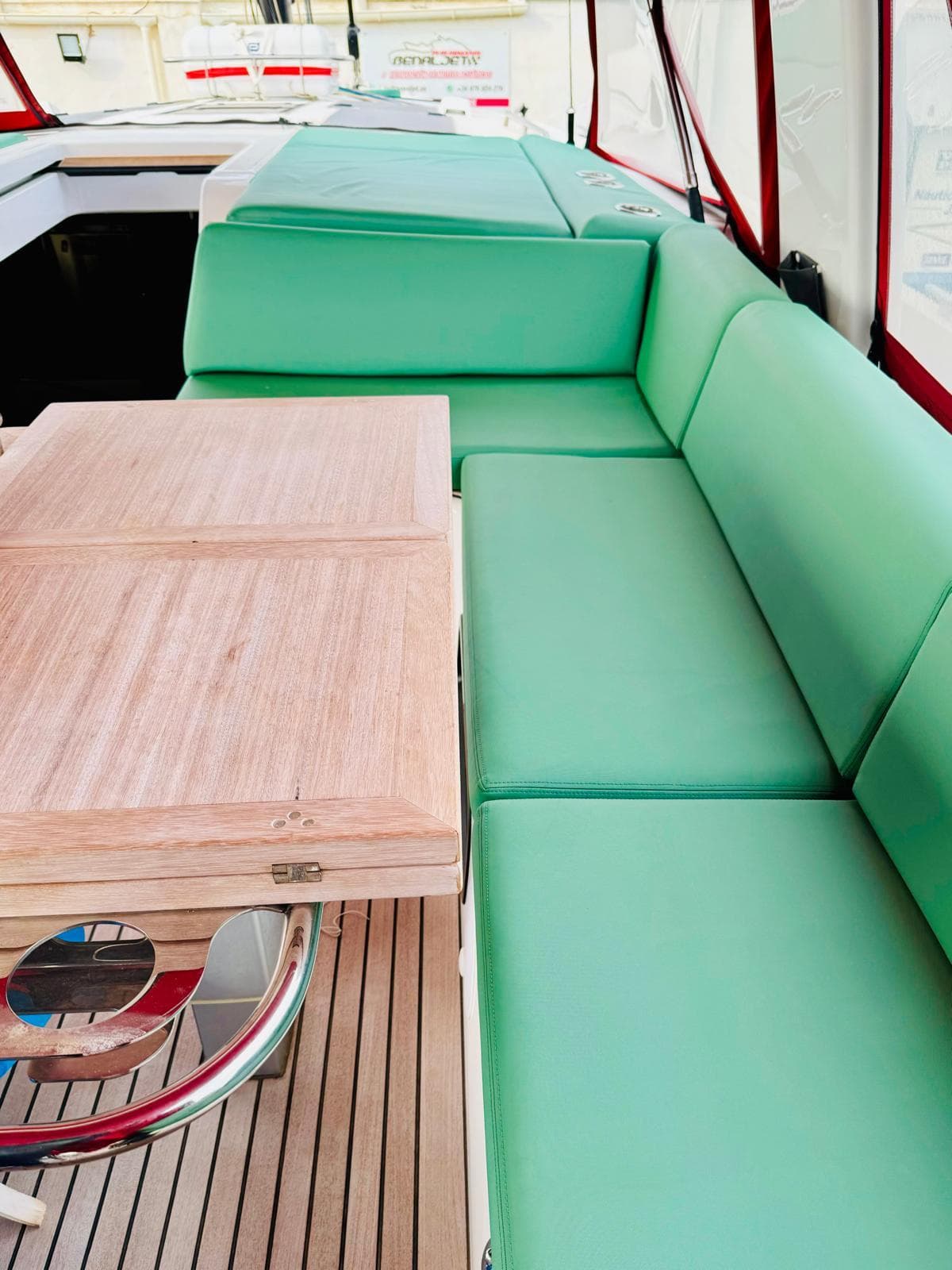 2023 Beneteau Oceanis Yacht 60 interior with green seating and wooden table.