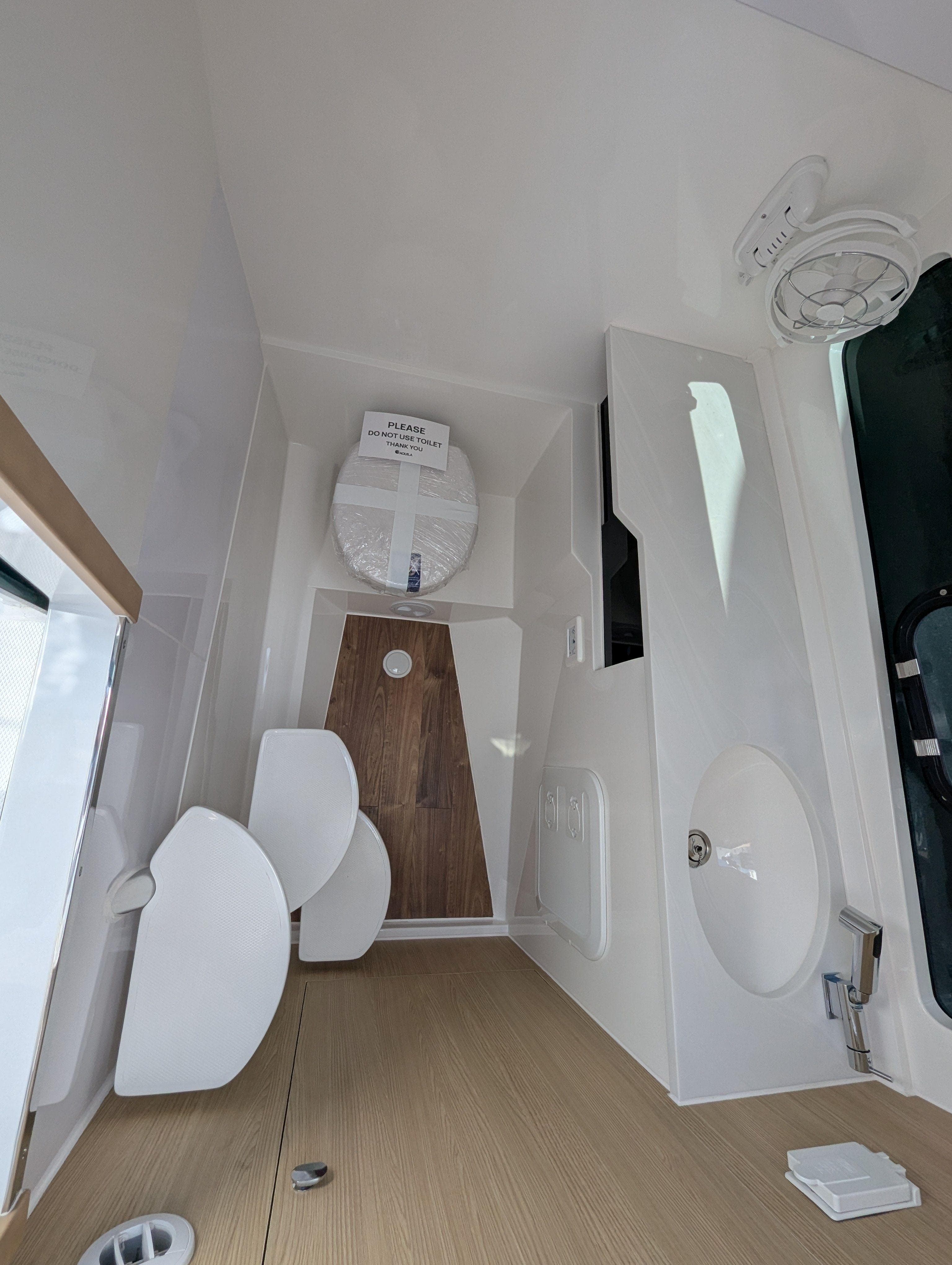 Interior of 2025 Aquila 32 Sport boat, featuring modern bathroom design and fixtures.
