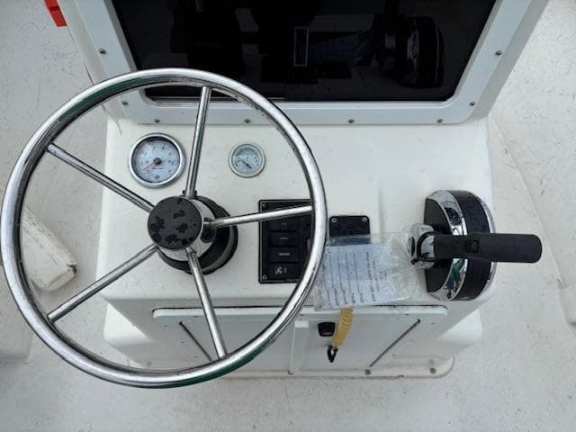 Steering console of 2021 May-Craft 1800 Skiff with gauges and throttle controls.