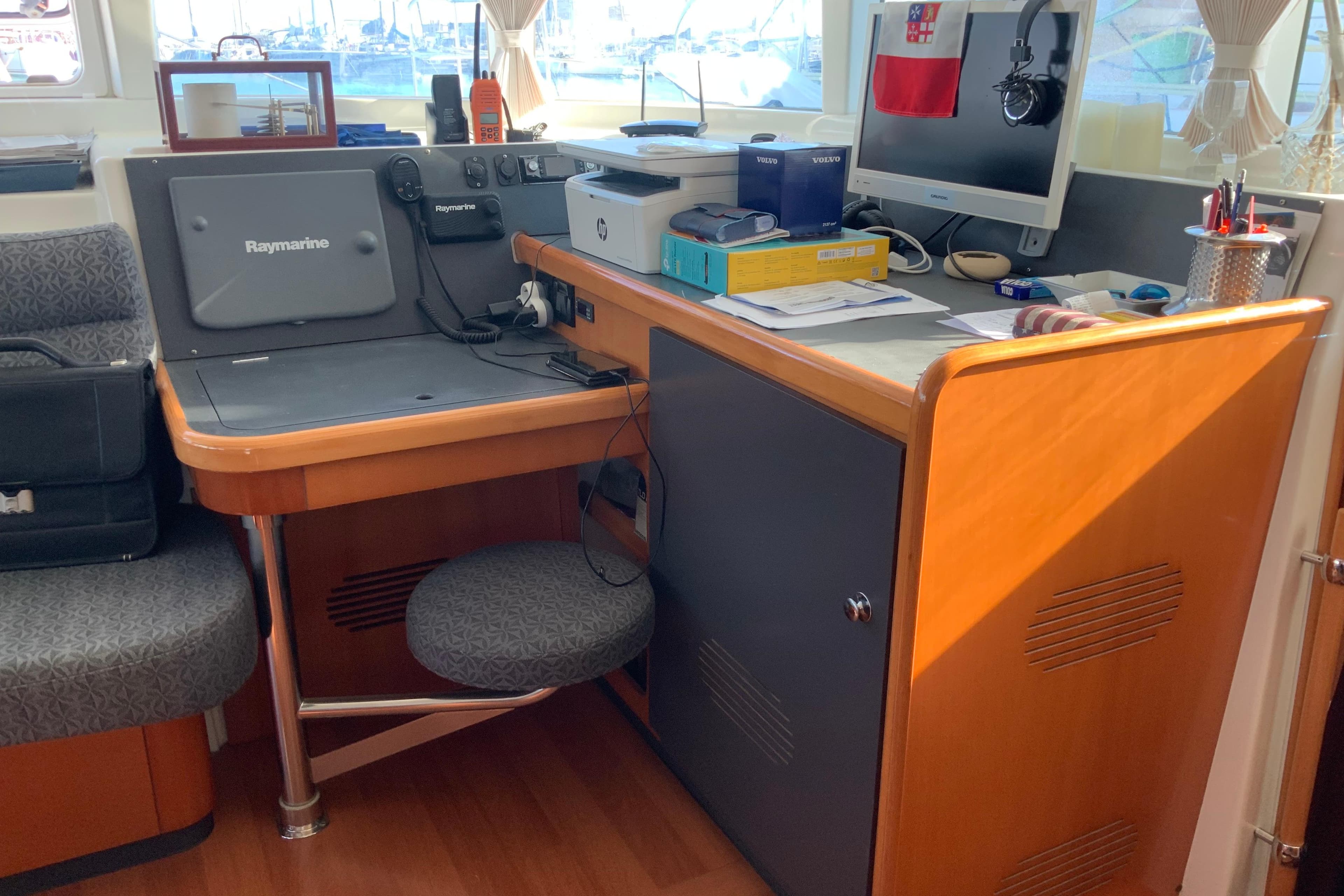 Navigation station inside a 2007 Lagoon 440 catamaran with Raymarine equipment and office setup.