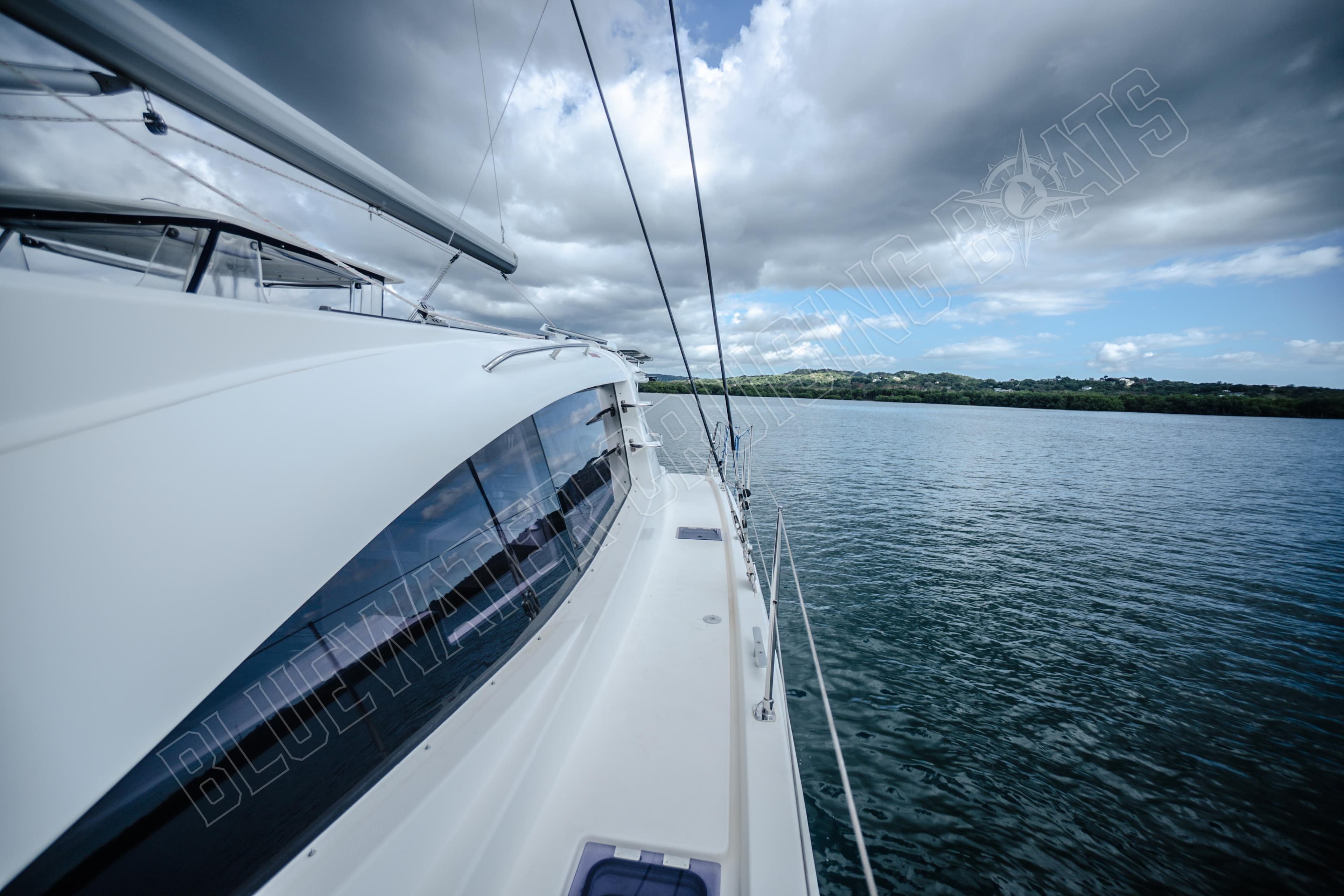 2015 Leopard 48 yacht sailing on calm waters under cloudy skies.