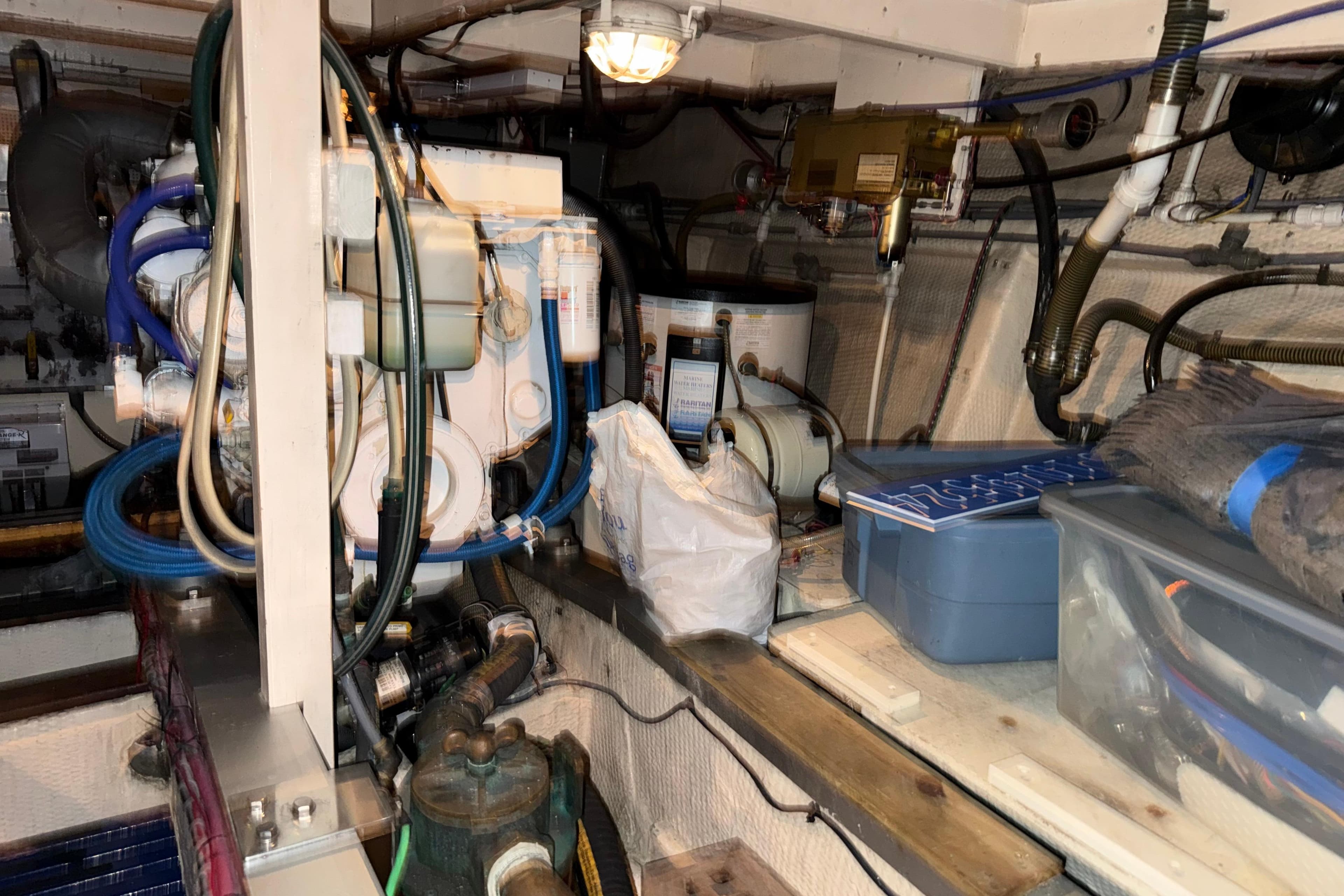 Engine room of 1991 Grand Banks 42 Classic with equipment and storage containers.