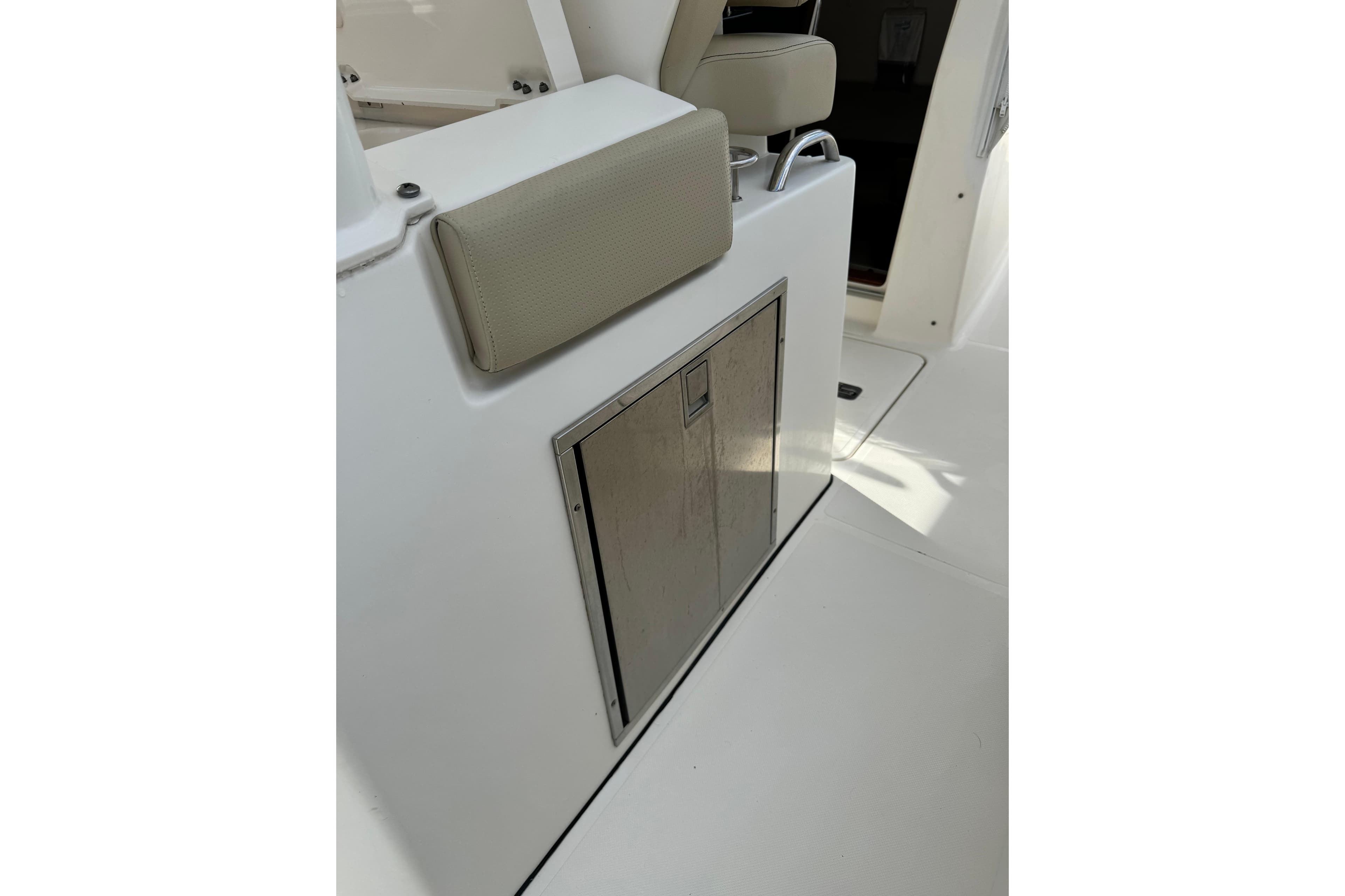 2018 Pursuit S 328 Sport boat interior with cushioned seating and storage compartment.