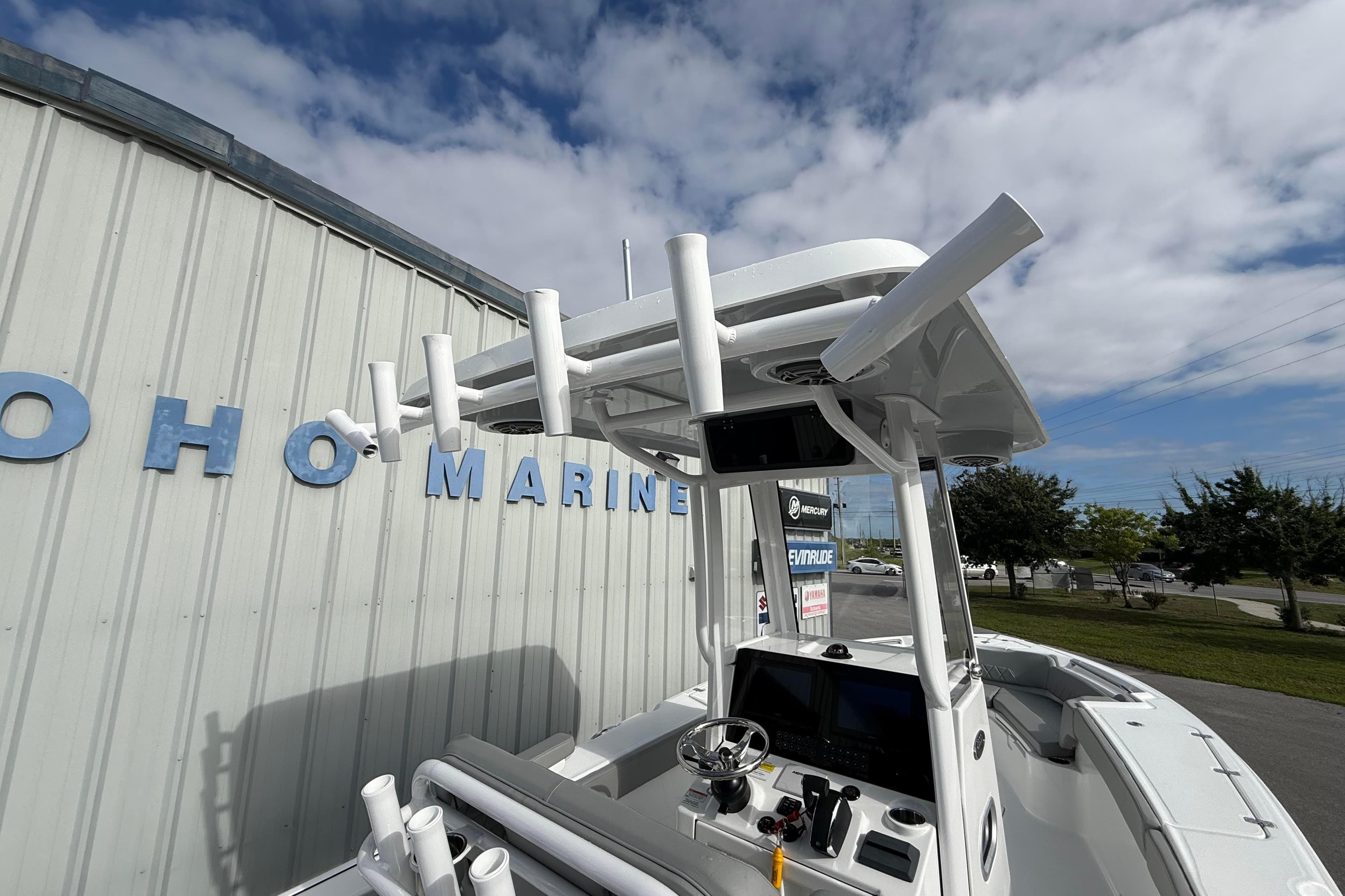 2026 Blazer Bay Makaira 2600 boat with rod holders, parked near a marine building.