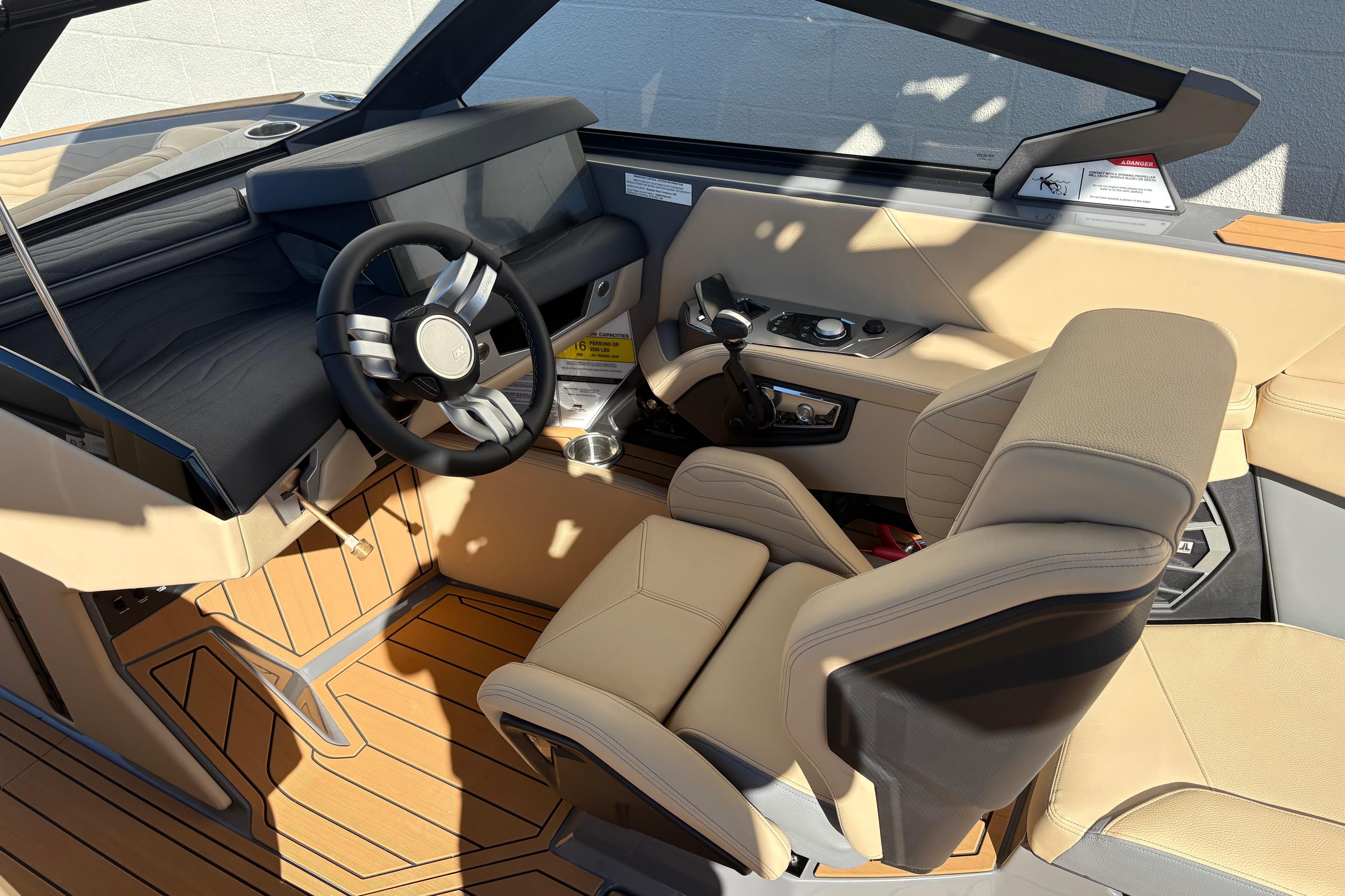 2026 Nautique Super Air Nautique G23 interior with beige seating and modern dashboard.