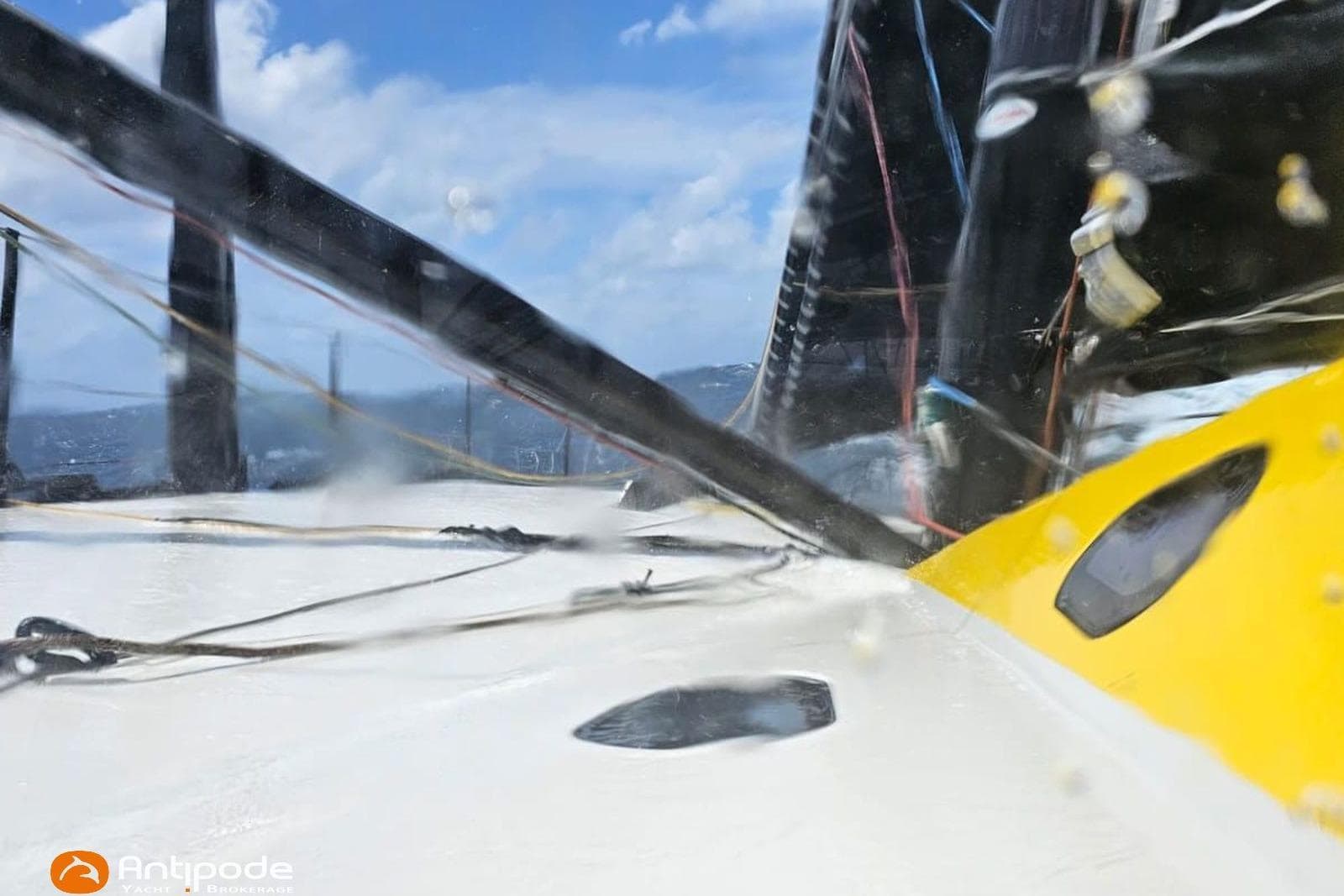 Sailing yacht Persico Imica 2023 navigating through waves under a clear blue sky.