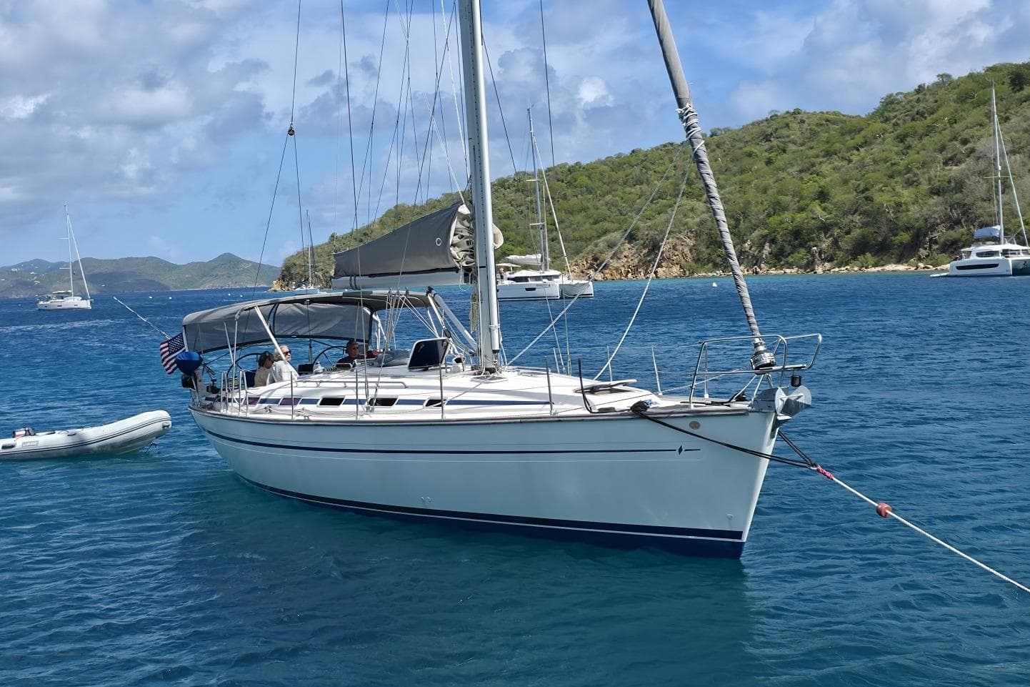 Sailing yacht Bavaria 44 (2003) anchored in clear blue waters near lush green islands.