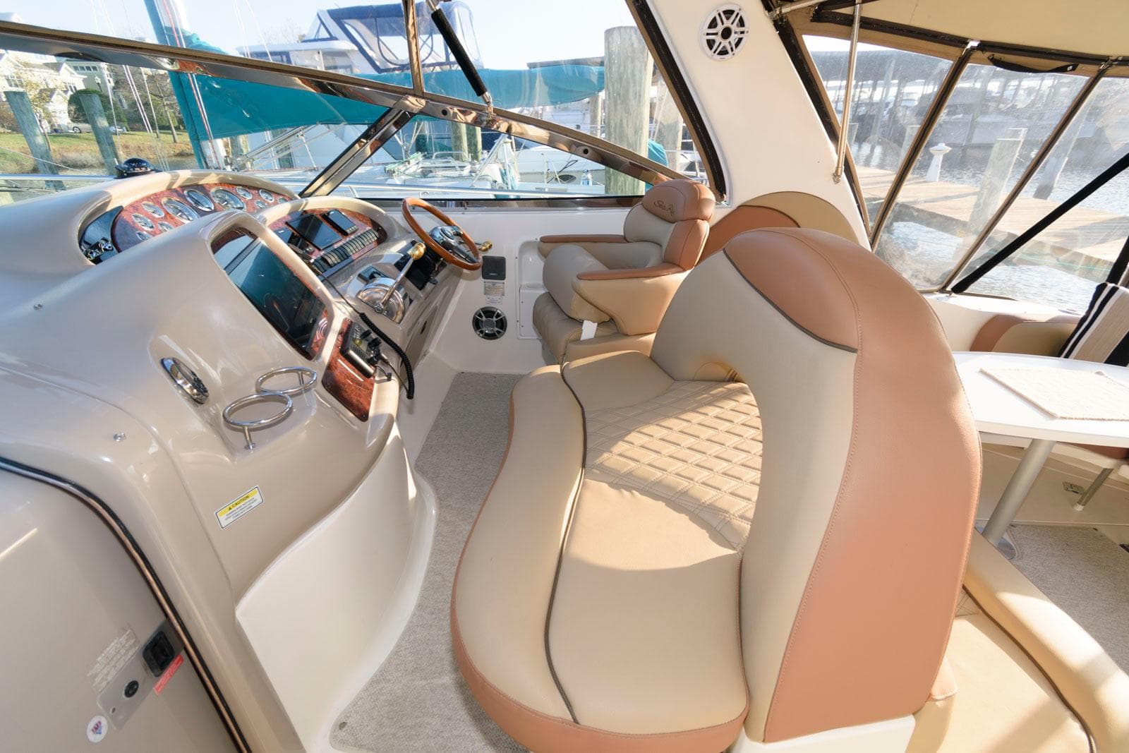 Interior of 2000 Sea Ray 380 Sundancer yacht with beige seating and helm.