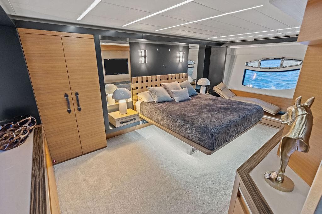 Luxurious bedroom interior of 2012 Pershing 92 yacht with modern decor and ocean view.