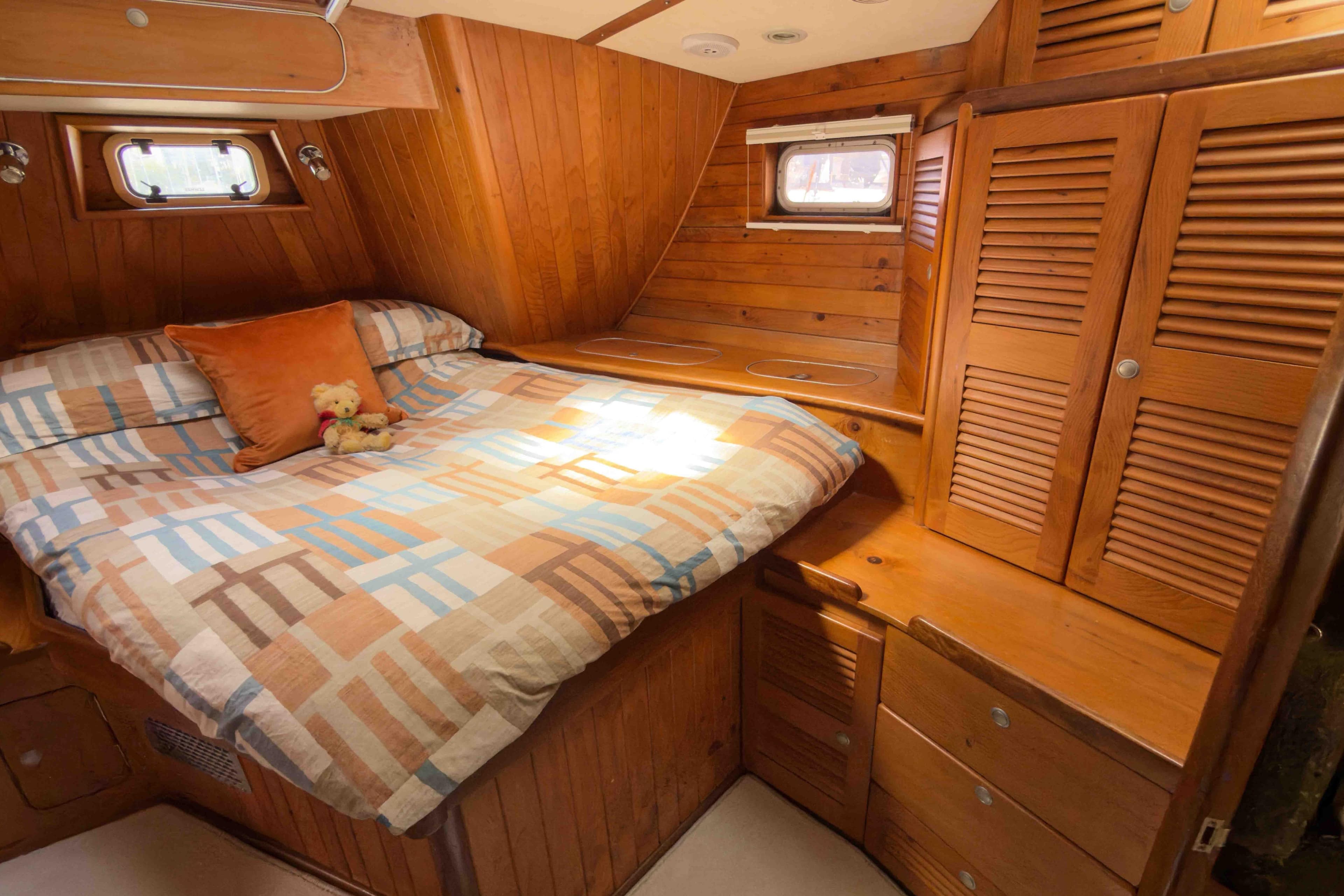 Cozy wooden cabin interior of 1994 Callisto 465 yacht with bed and storage.