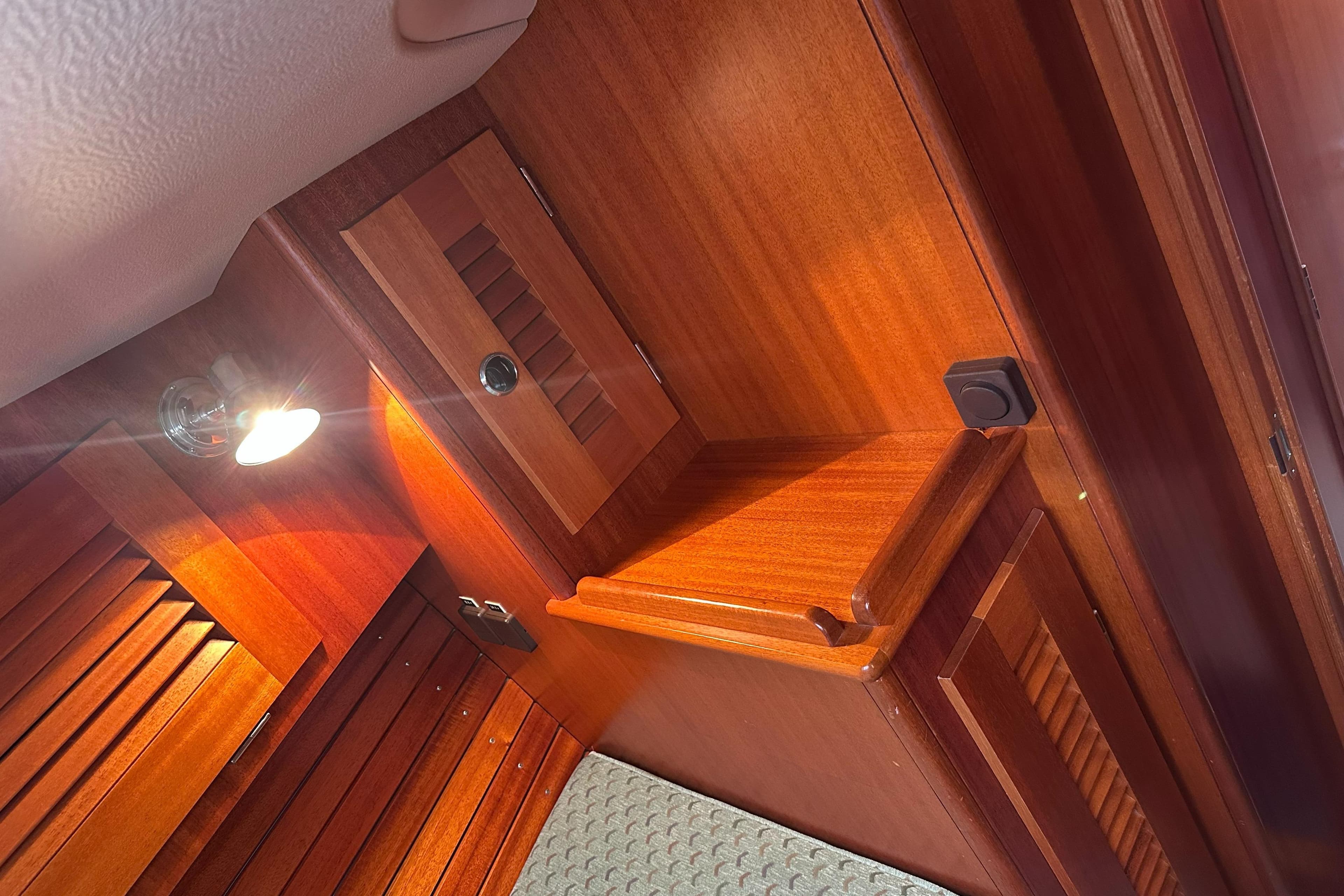 Interior of 2000 Hallberg-Rassy 46 yacht with wooden cabinetry and ambient lighting.