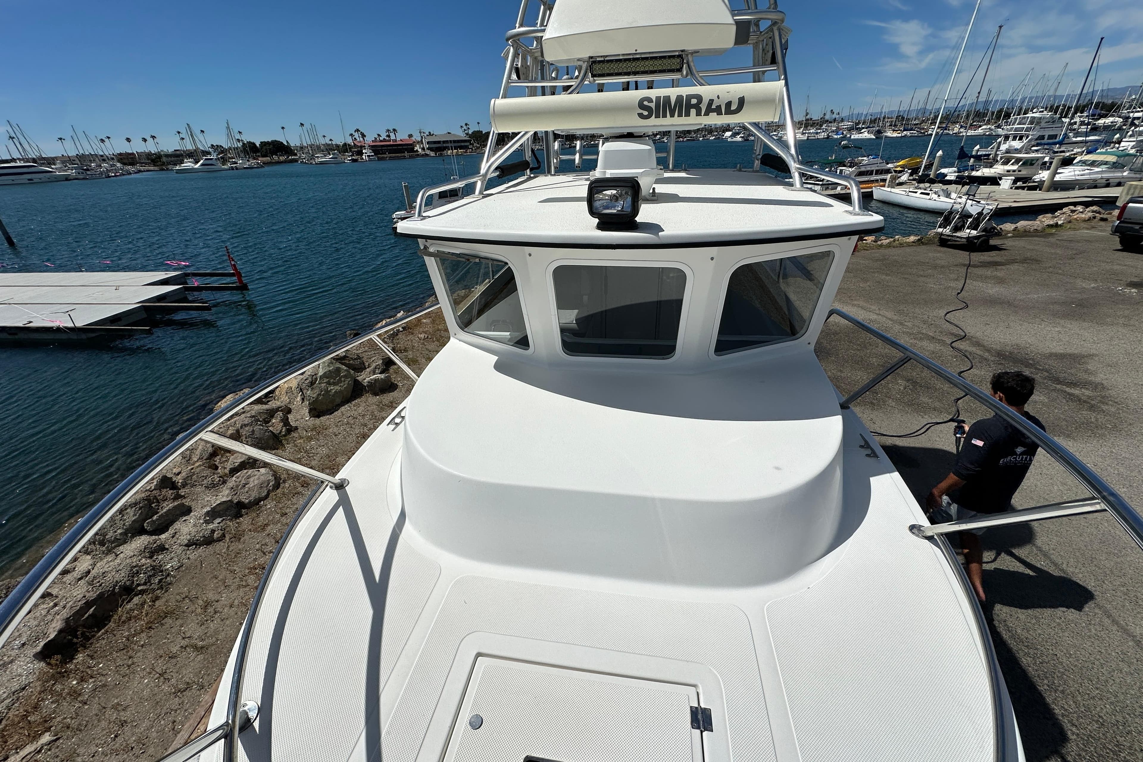 2012 Davis Rock Harbor 25 boat docked at marina, clear sky, calm water.