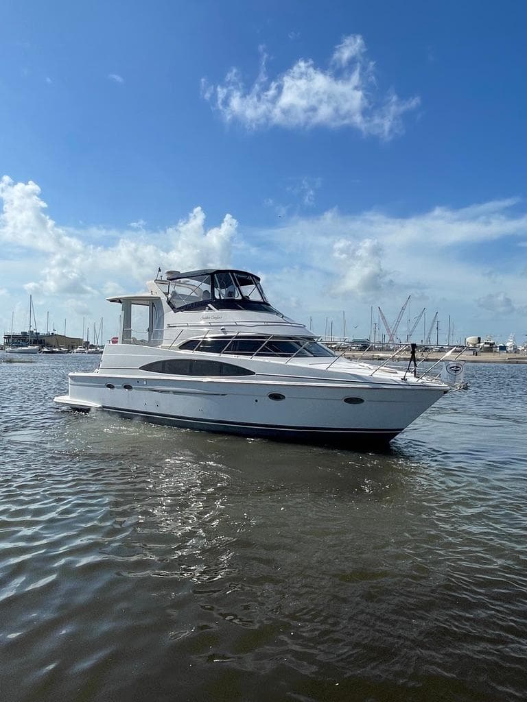 2001 Carver 444 Cockpit Motor Yacht on calm water under blue sky.