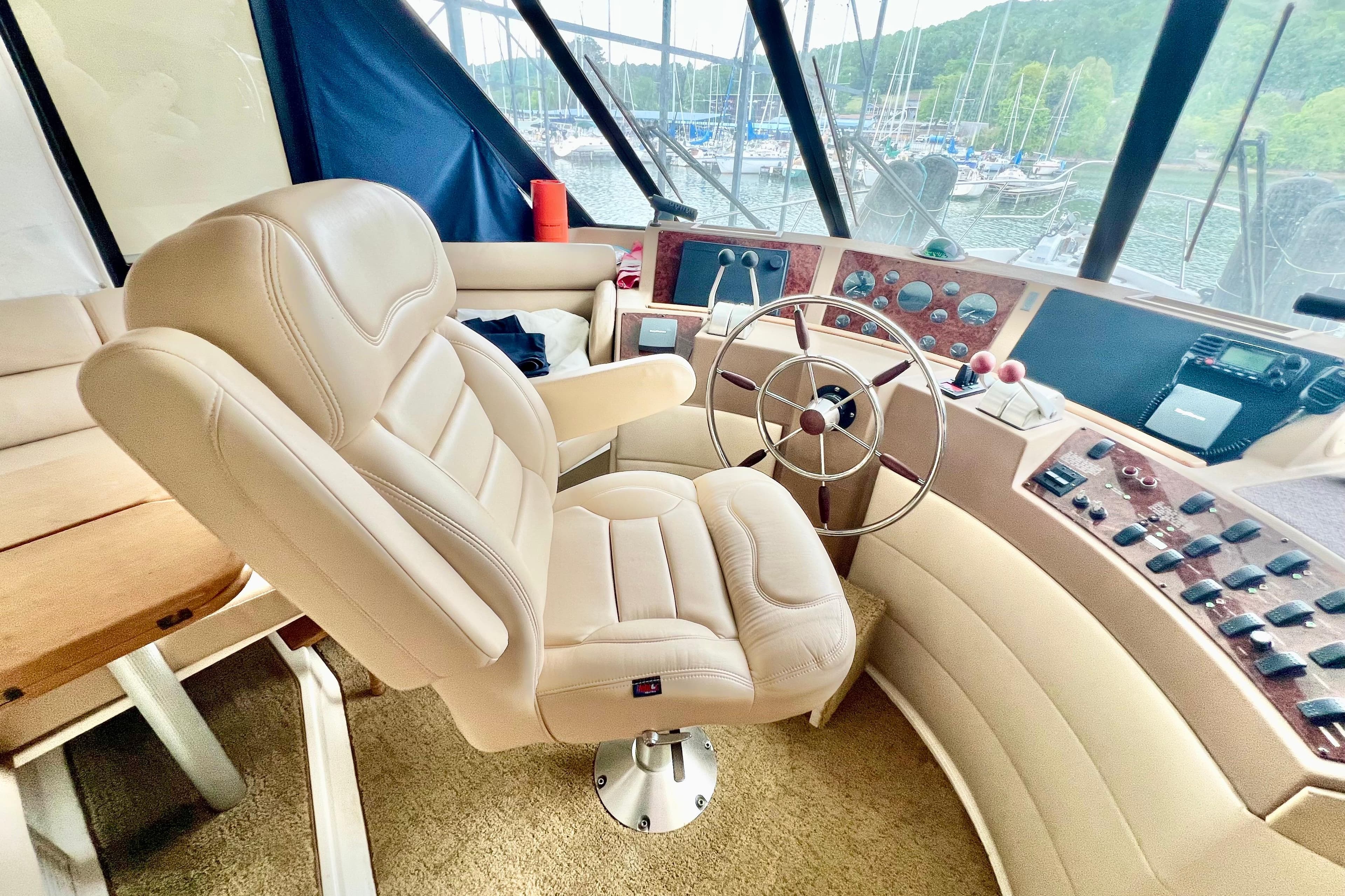 Luxurious helm of 2001 Bayliner 4788 Pilot House Motoryacht with plush seating and controls.