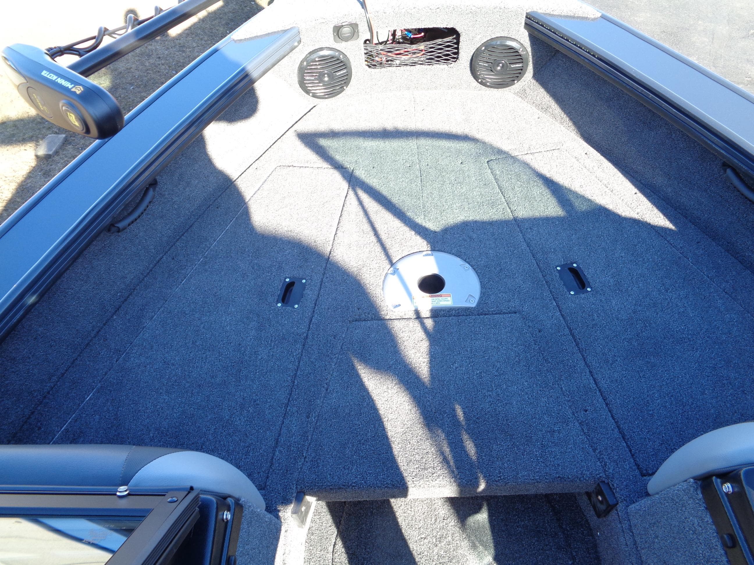2024 Lund 1875 Fisherman boat interior with carpeted deck and storage compartments.